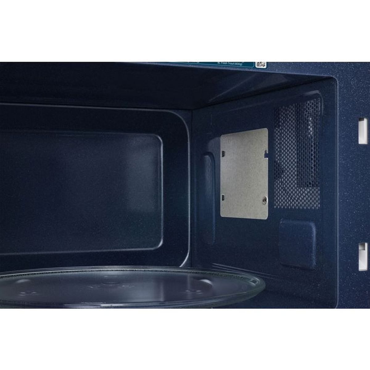 Interior of a dark microwave with a glass turntable and metal plate.