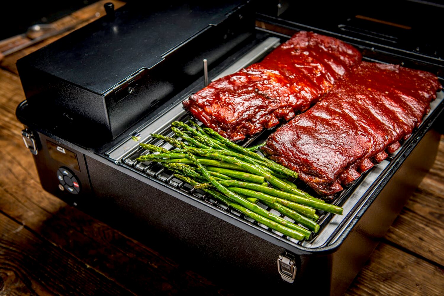 Costine barbecue e asparagi su una griglia
