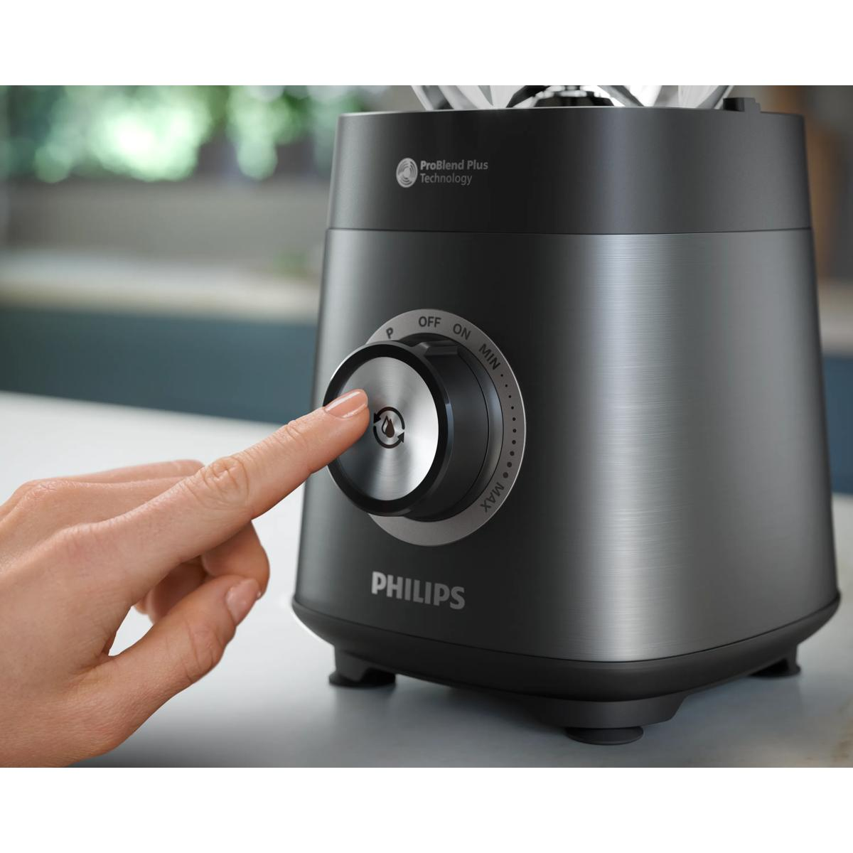Una mano preme la manopola di un frullatore Philips nero con etichetta ProBlend Plus Technology.