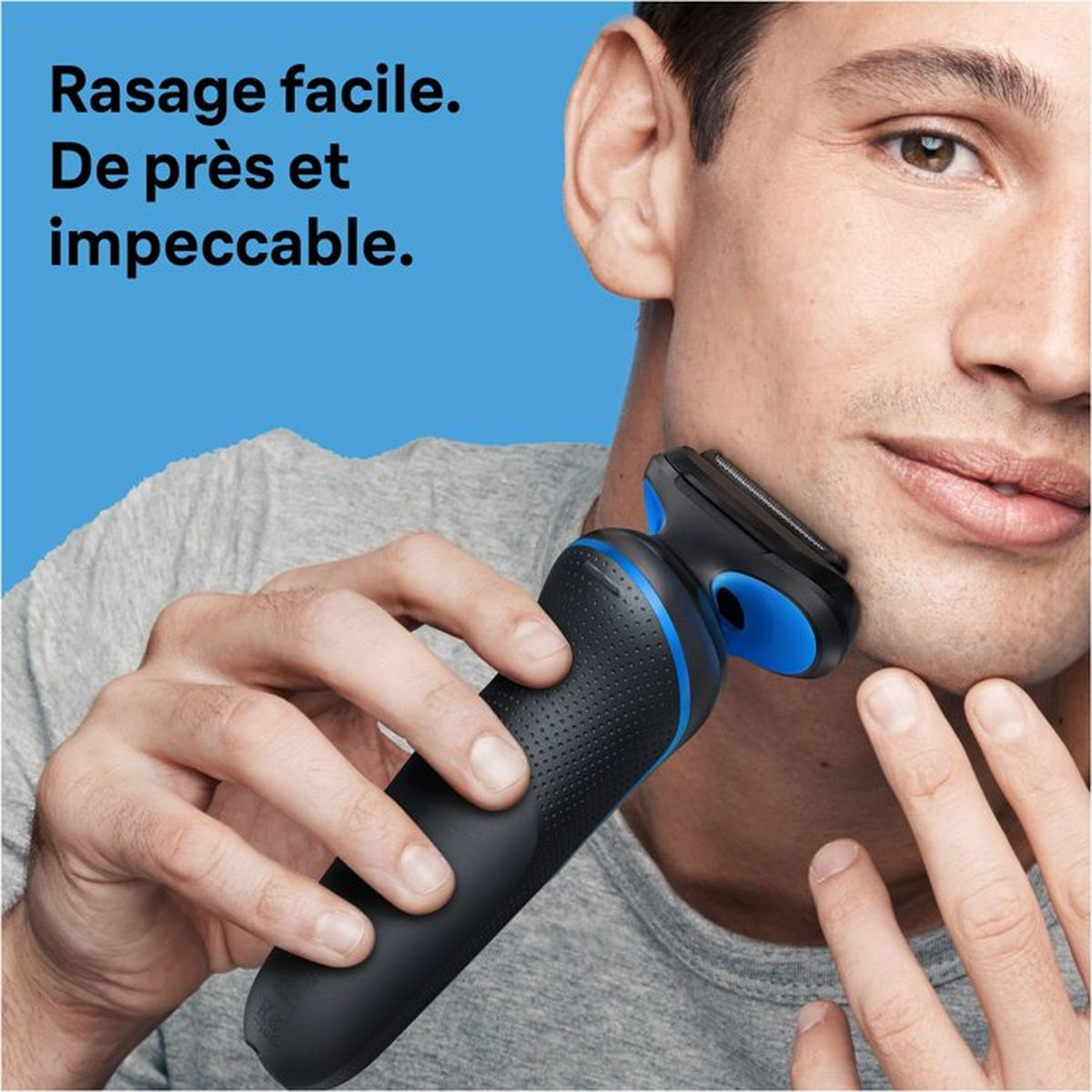 Mann rasiert sich mit einem schwarzen und blauen elektrischen Rasierer.