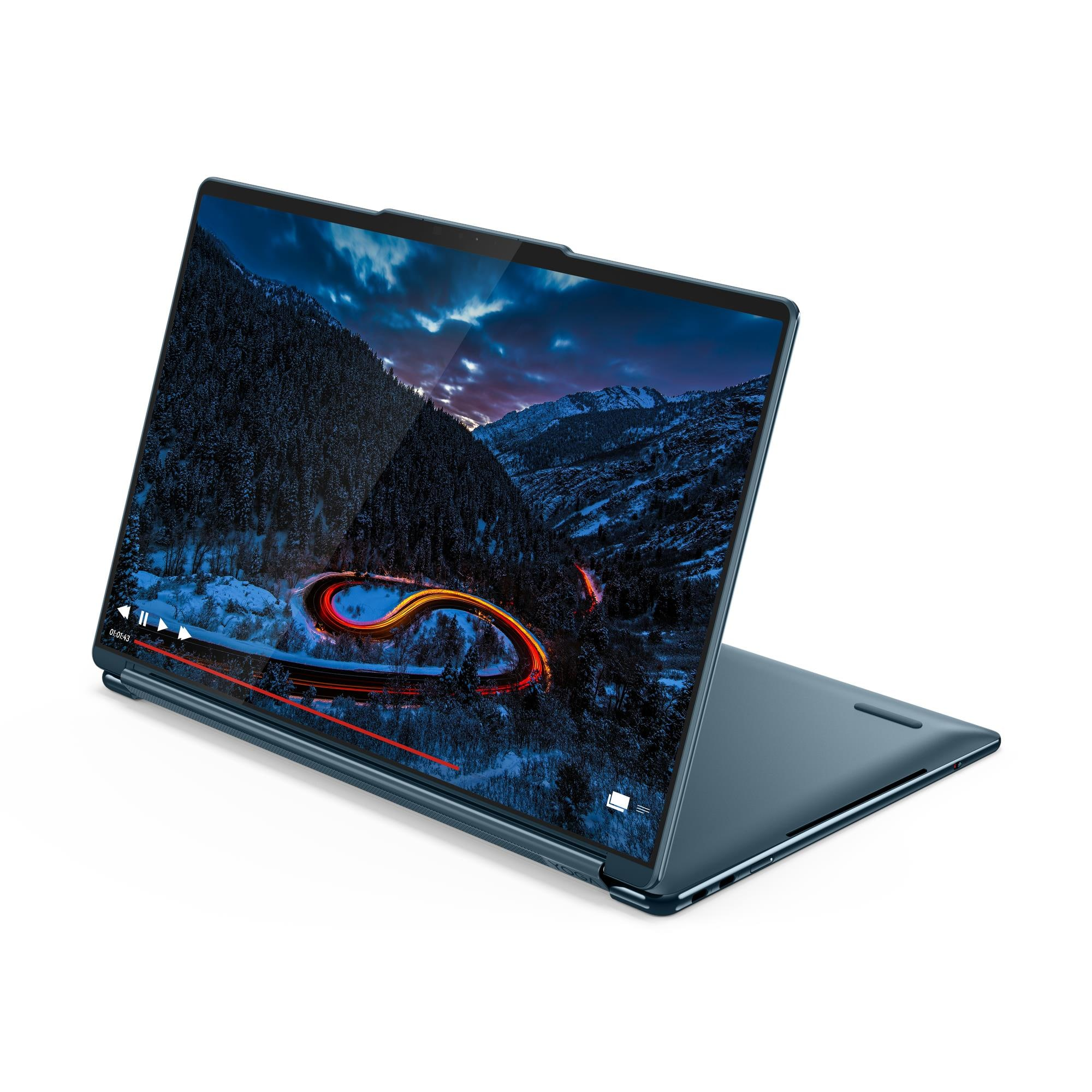 Un laptop blu mostra un paesaggio montano innevato con una strada tortuosa di notte.