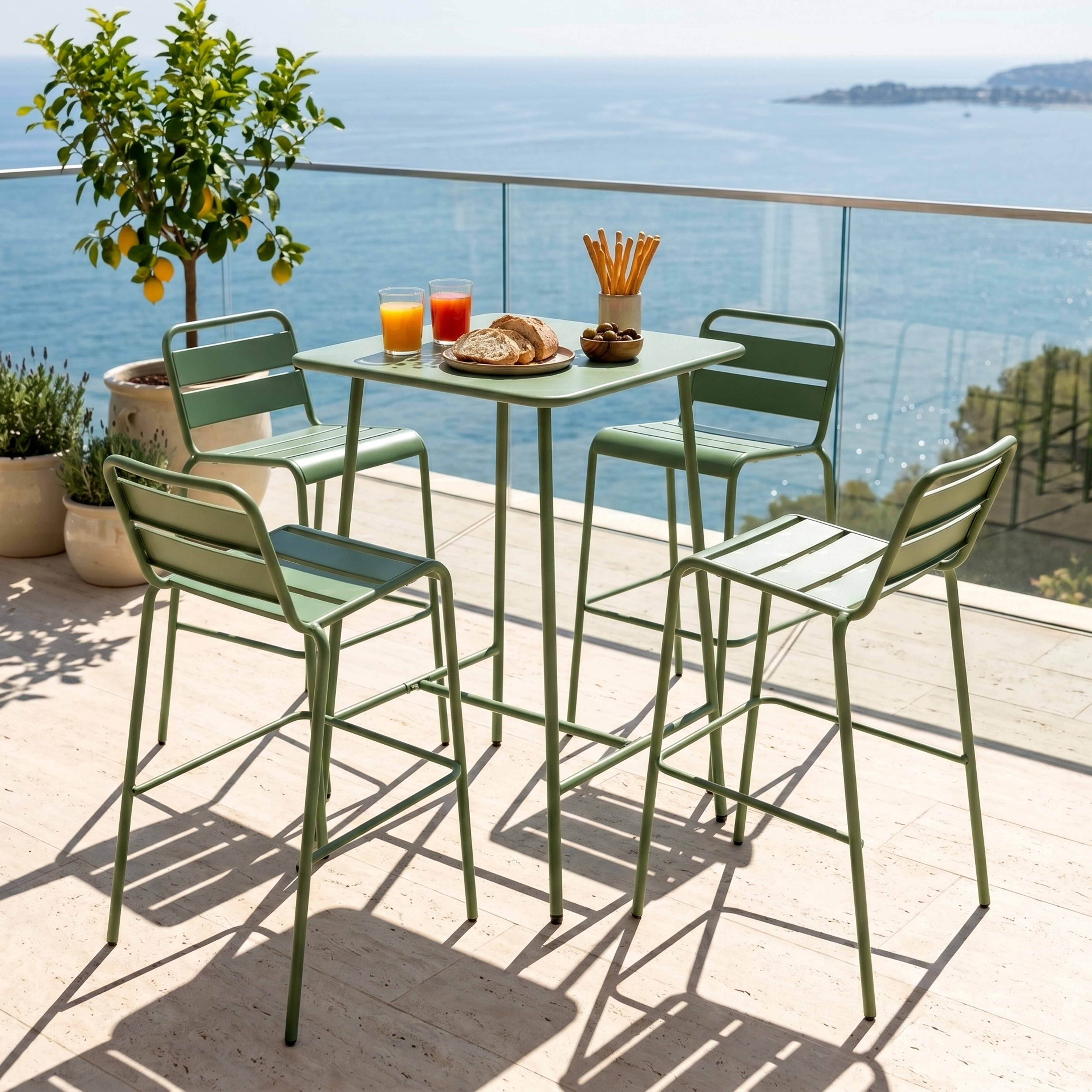 Grüne Barstühle und Tisch auf einer Terrasse mit Blick aufs Meer.