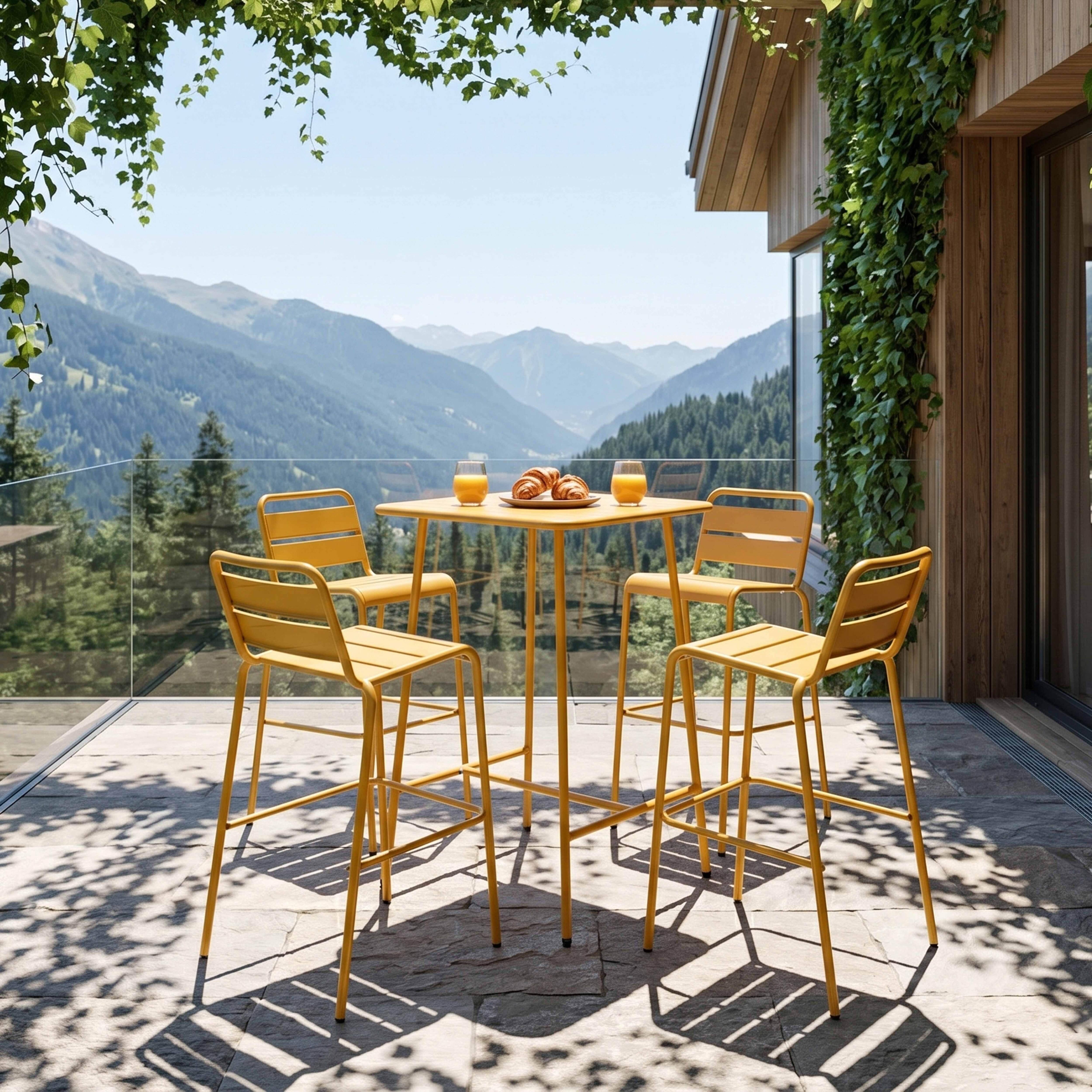 Gelbe Hochtischgarnitur mit Blick auf die Berge, mit zwei Gläsern Saft und Croissants.