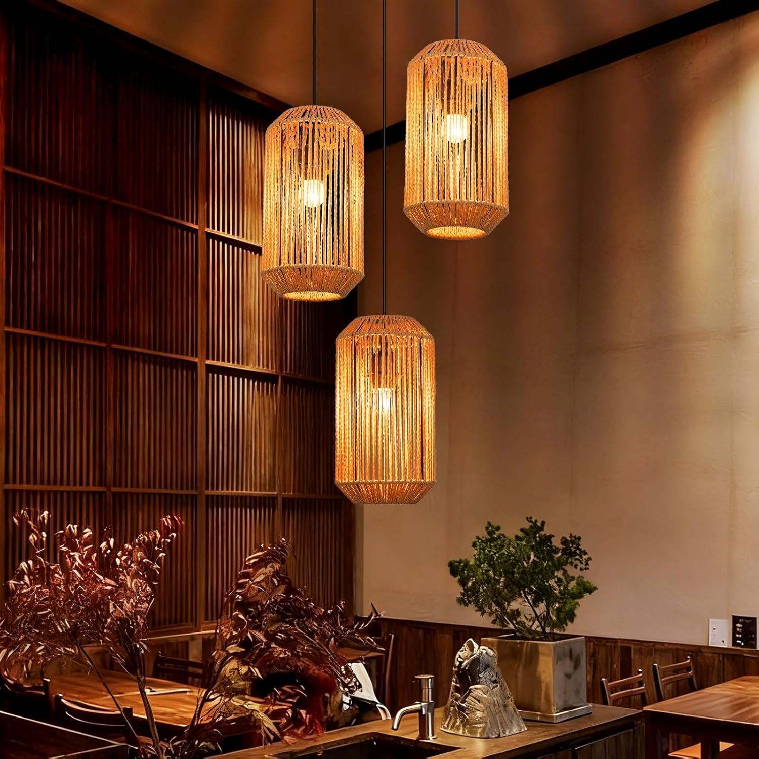 Tre lampade a sospensione in corda con lampadine in un ristorante con pareti in legno.