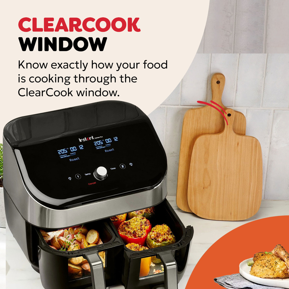A black double air fryer with stuffed peppers and potatoes inside.