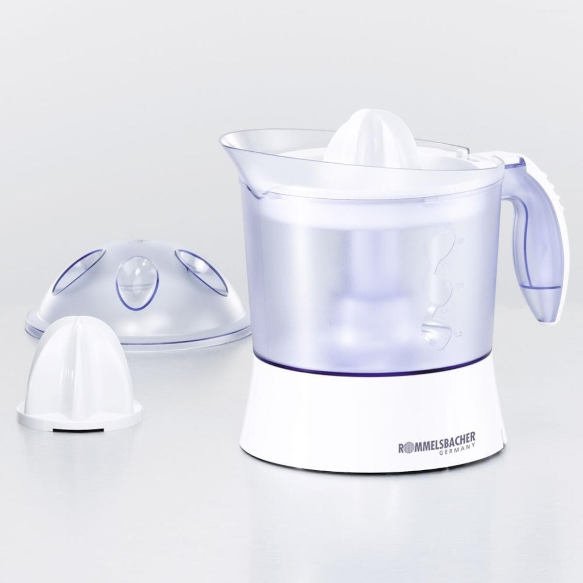 Un spremiagrumi bianco e trasparente con accessori su una superficie grigia.