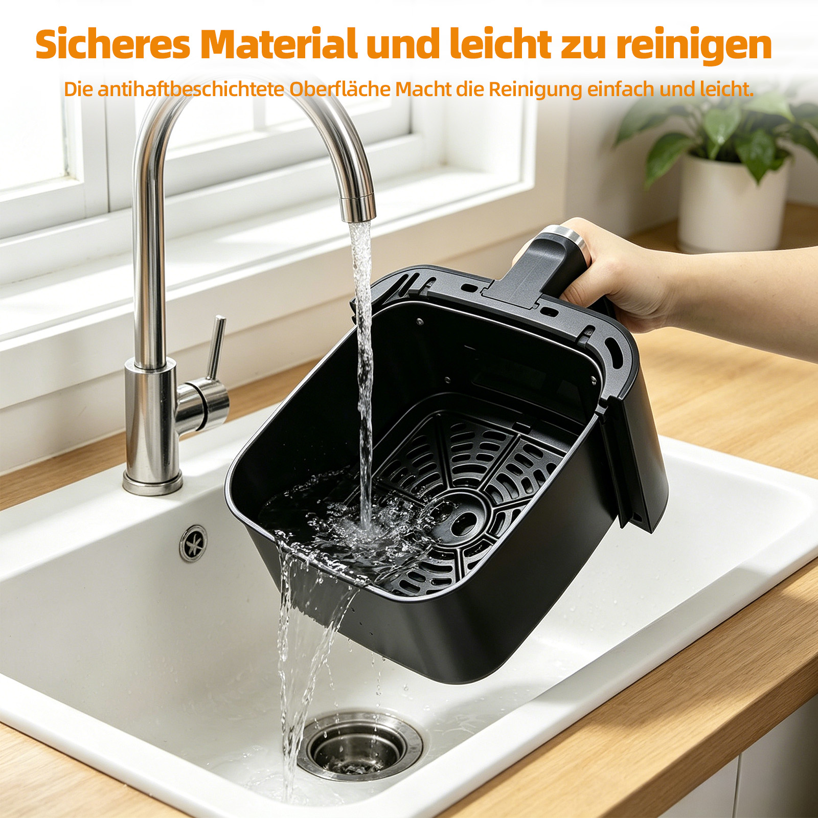 Ein schwarzer Airfryer-Korb wird unter fließendem Wasser in einer weißen Spüle gereinigt.