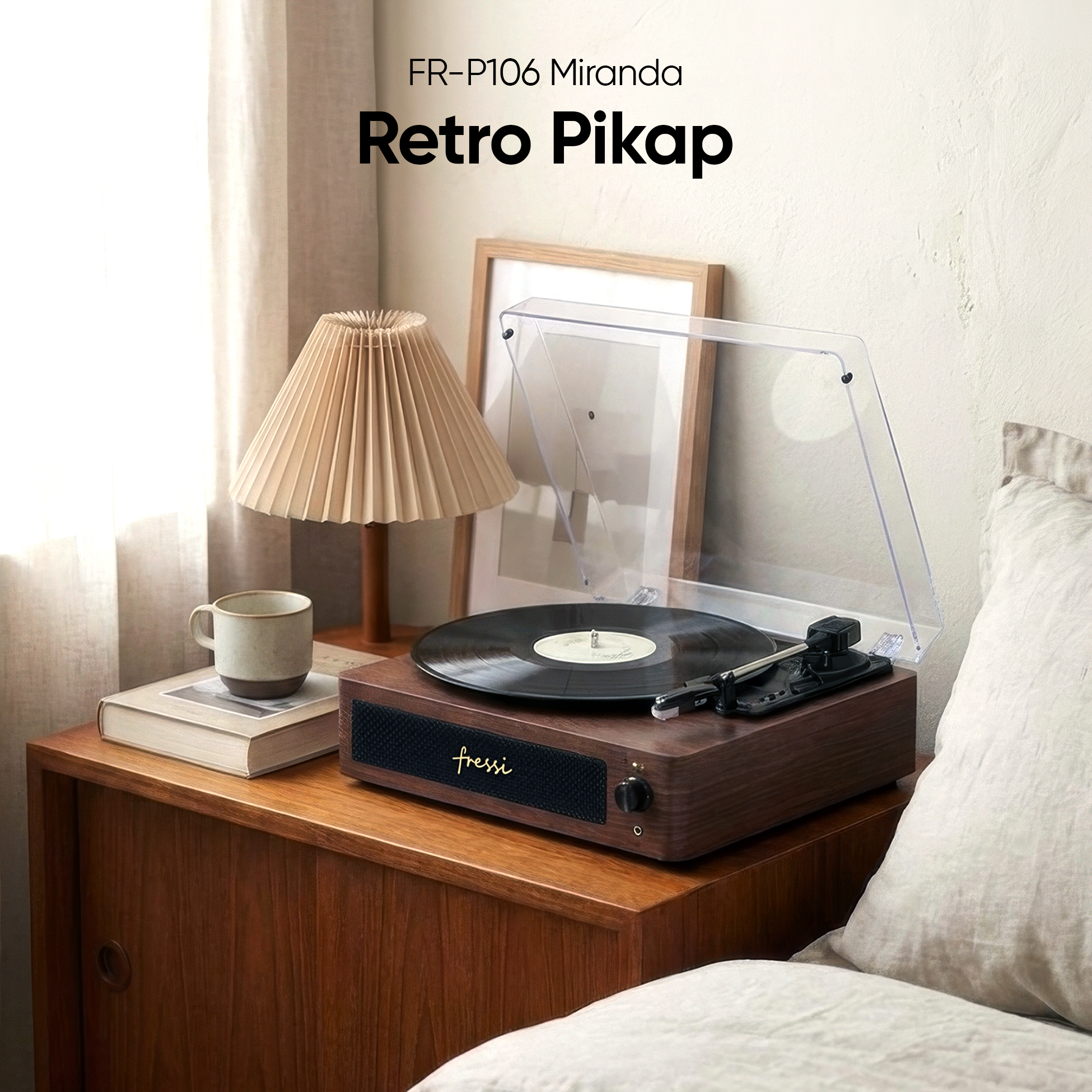 Ahşap bir dolabın üzerinde kitap ve kupa yanında retro tarzı bir pikap duruyor.