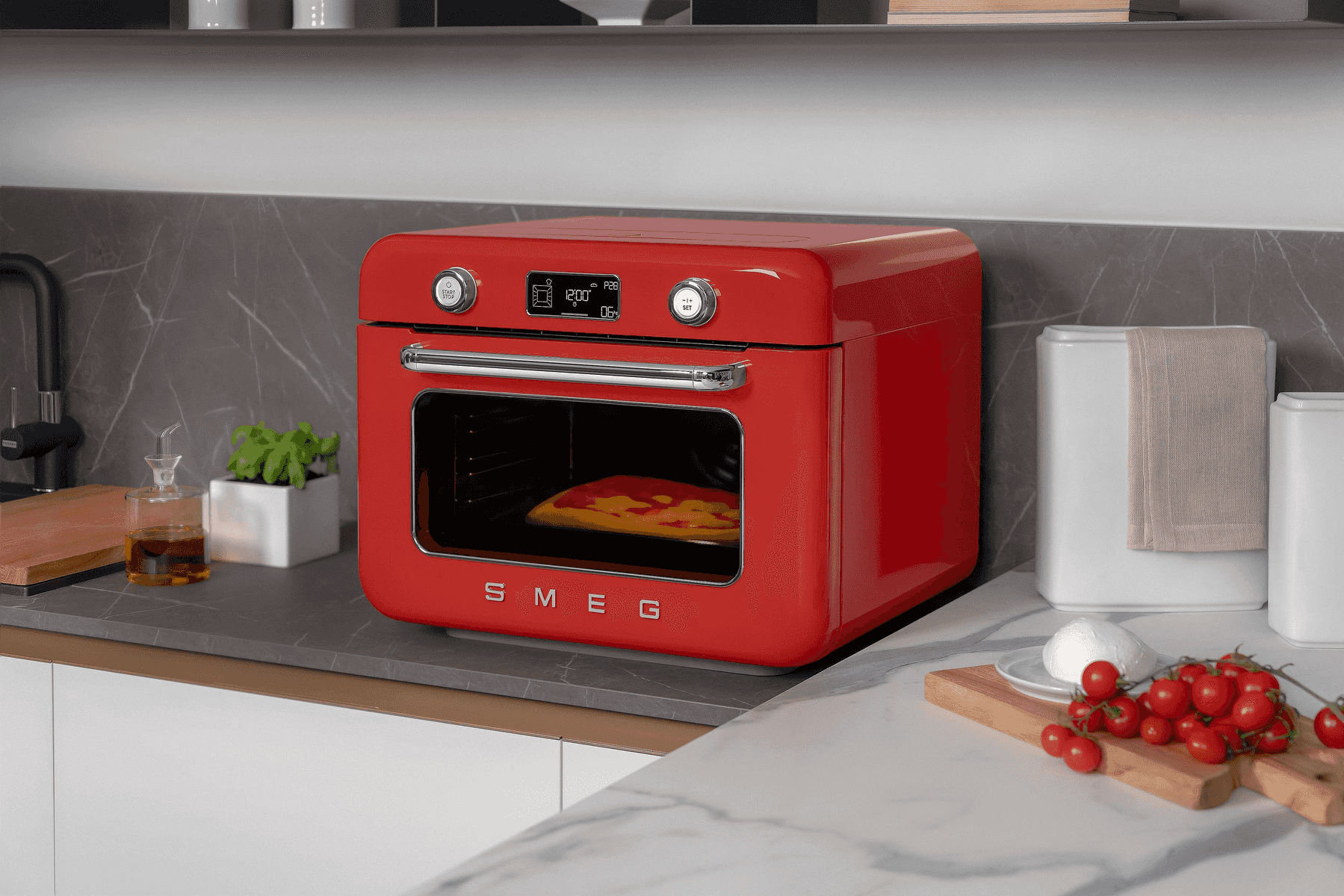 Un horno SMEG rojo con una pizza dentro está sobre una encimera de cocina.