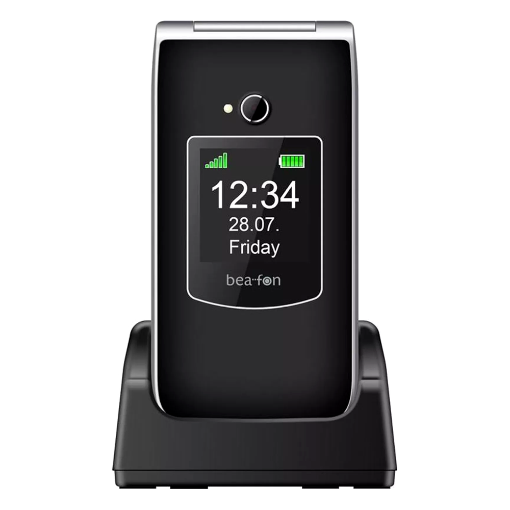 Un telefono a conchiglia nero su base di ricarica mostra le 12:34.
