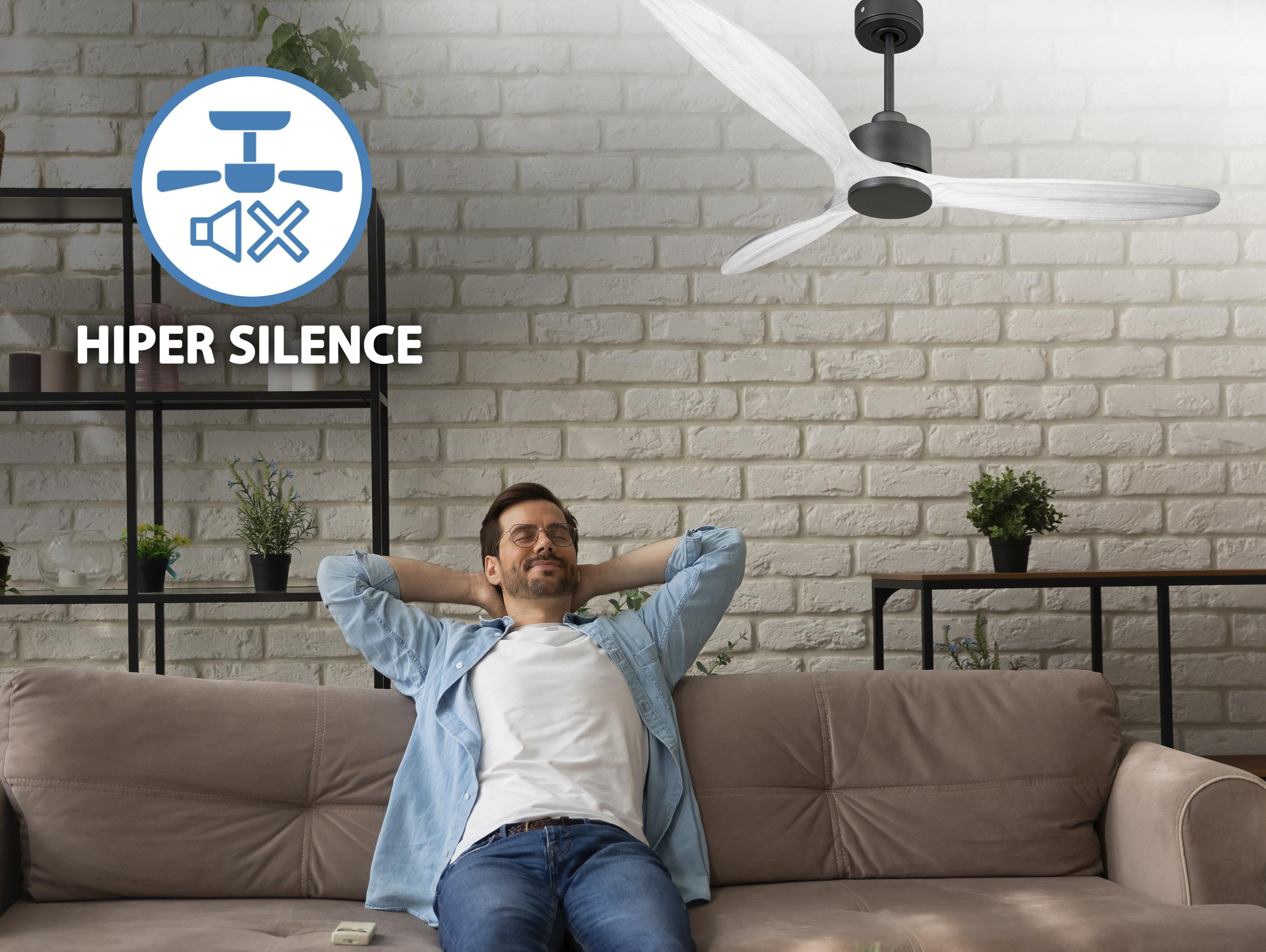 Hombre relajándose en el sofá frente a pared de ladrillos con ventilador de techo.