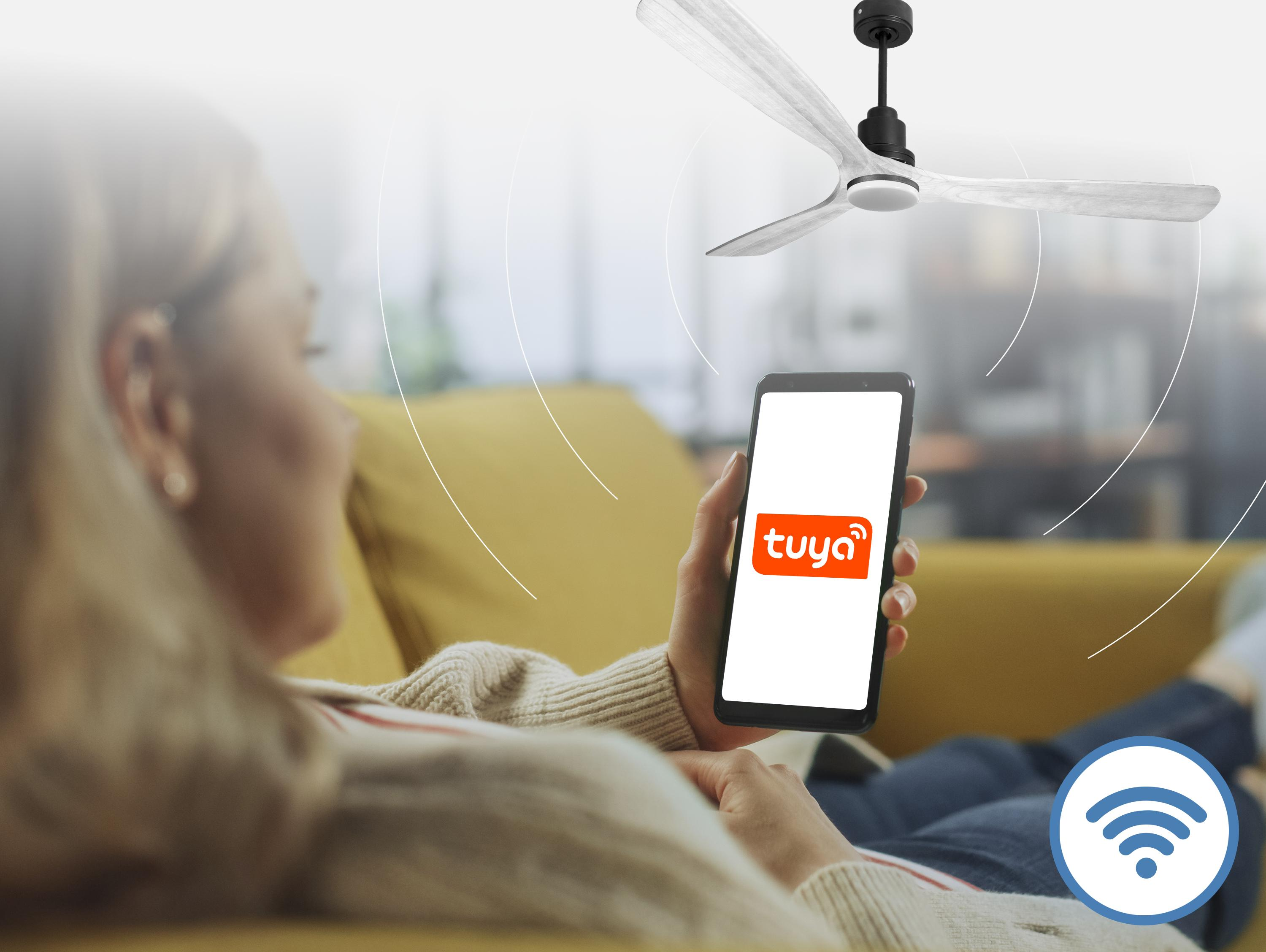 Mujer en sofá usa app Tuya en móvil para controlar ventilador de techo.