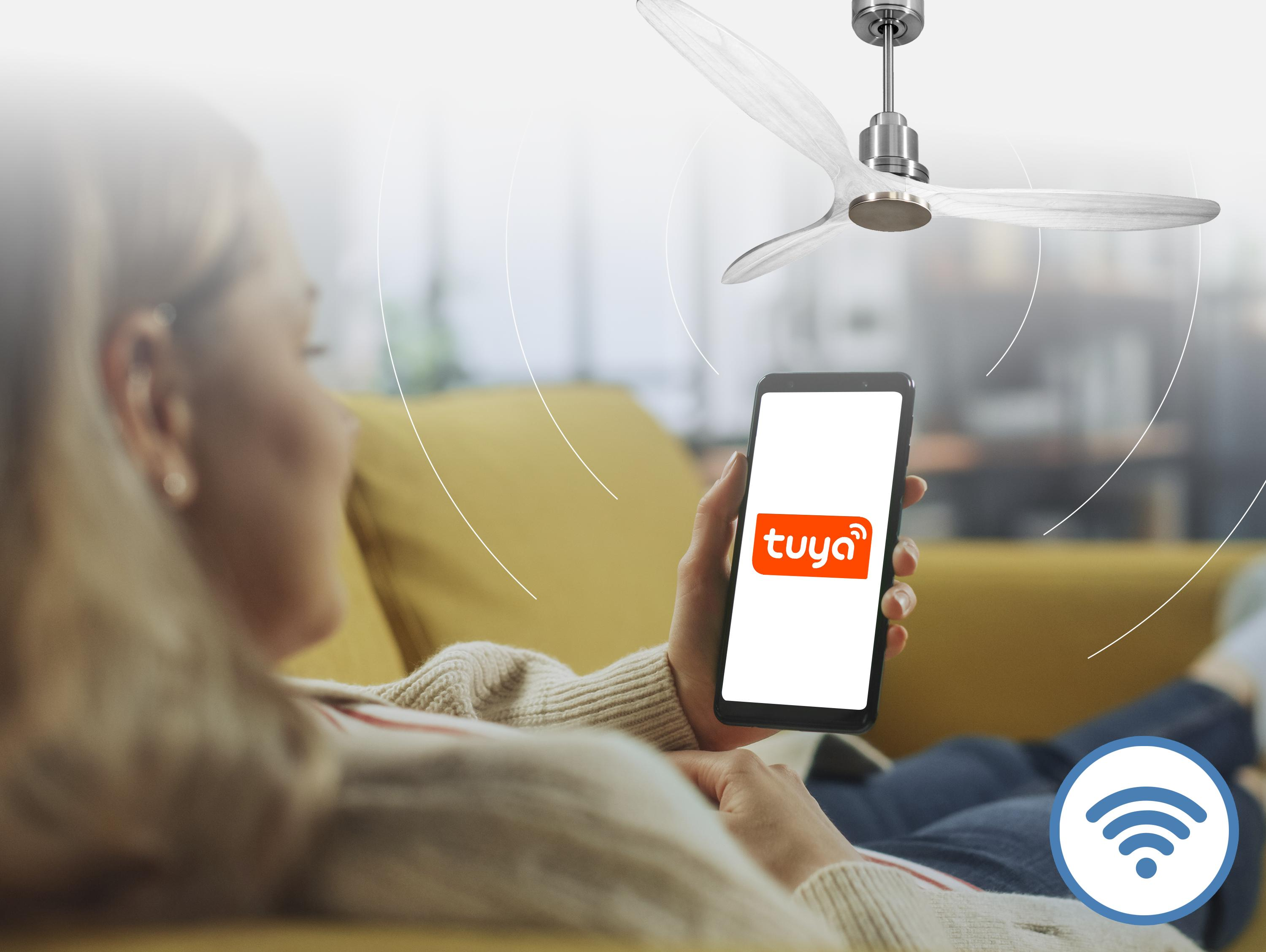 Una mujer yace en un sofá sosteniendo un smartphone con el logo de Tuya.