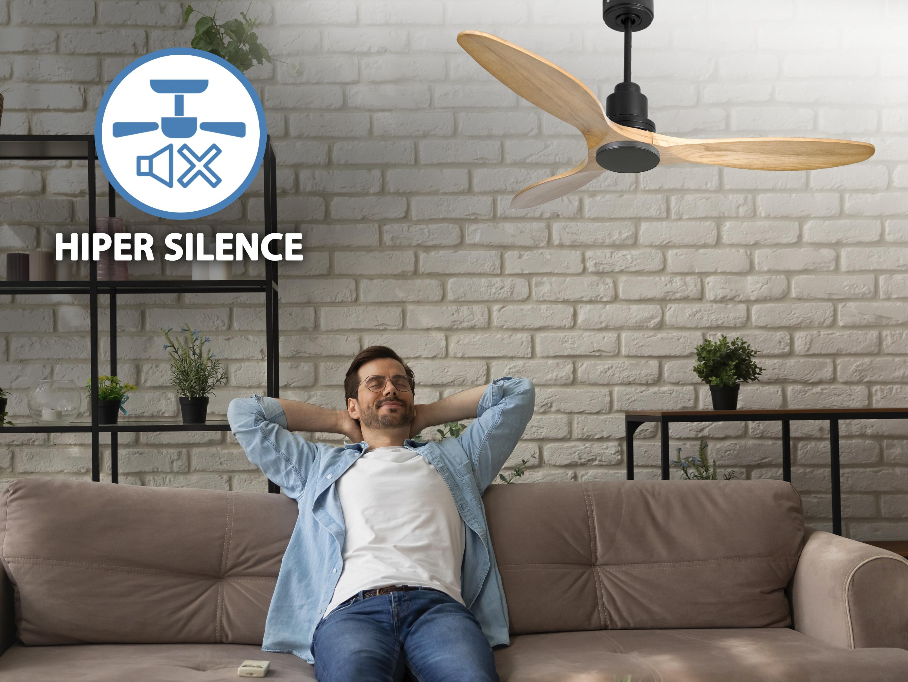 Un hombre se relaja en un sofá con un ventilador de techo encima. Texto: HIPER SILENCE.