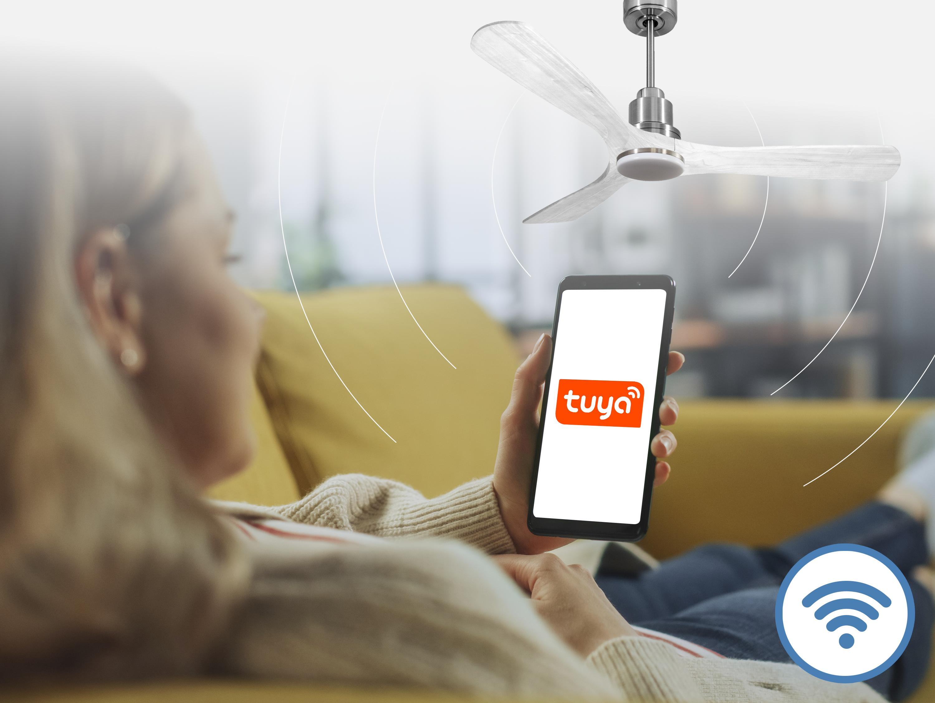 Mujer controla ventilador de techo con smartphone y app Tuya. Símbolo WiFi.