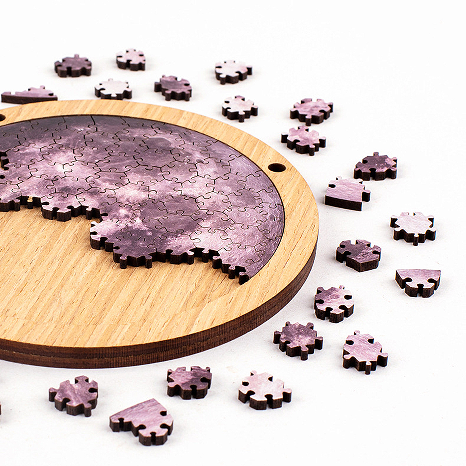 Puzzle di legno della luna su base rotonda di legno con pezzi sparsi.