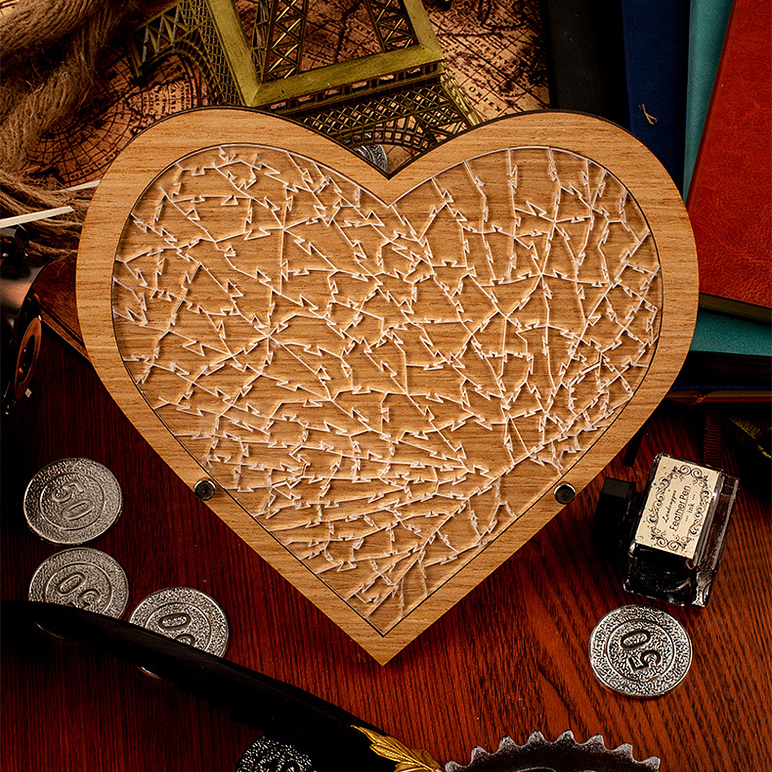 Puzzle a forma di cuore in legno con motivi intricati, monete, calamaio e mappe.