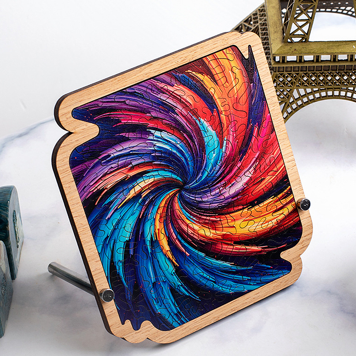 Un puzzle in legno con un vorticoso motivo colorato nei toni del blu, rosso e giallo su un supporto.