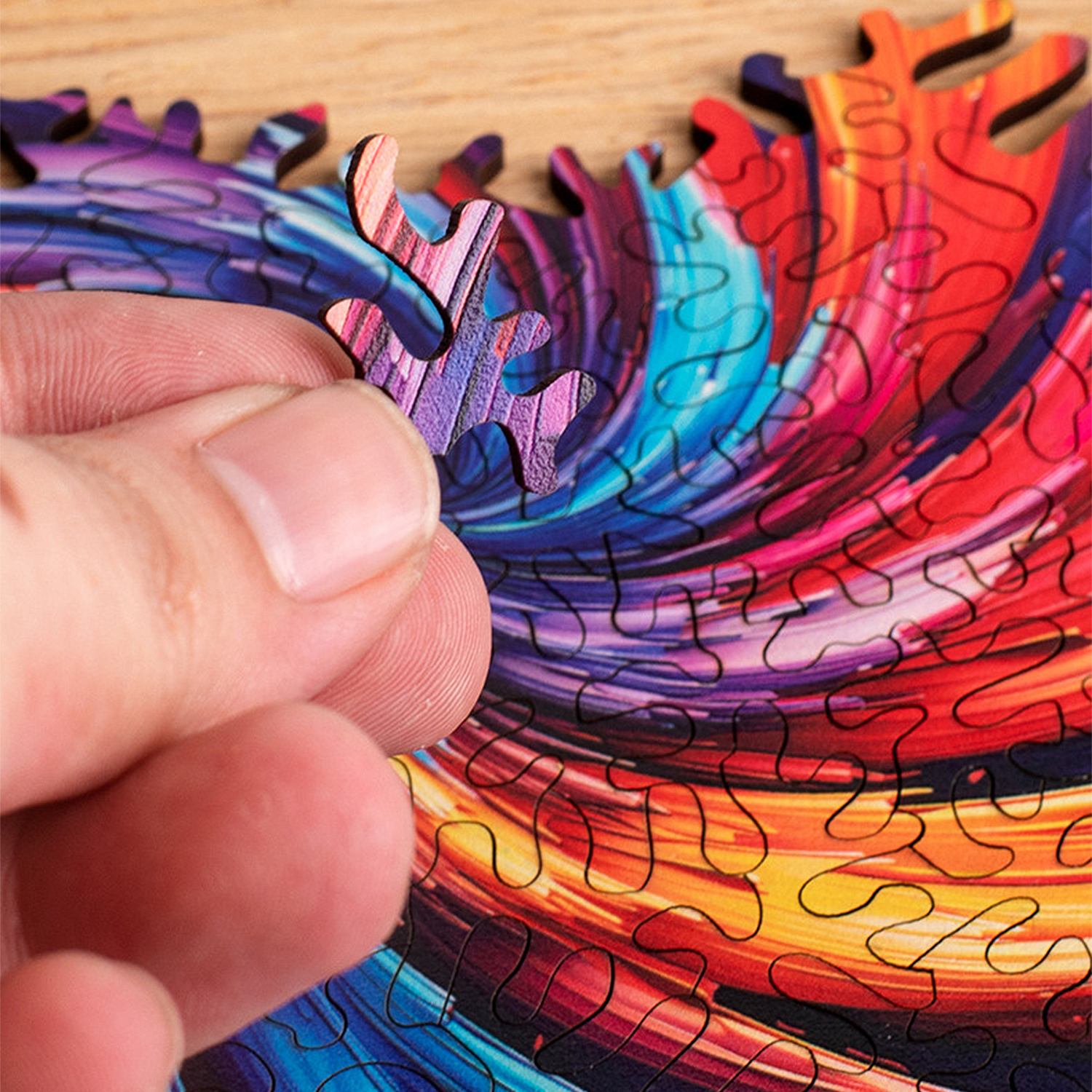 Una mano tiene un pezzo del puzzle colorato su uno sfondo sfocato di pezzi del puzzle colorati.