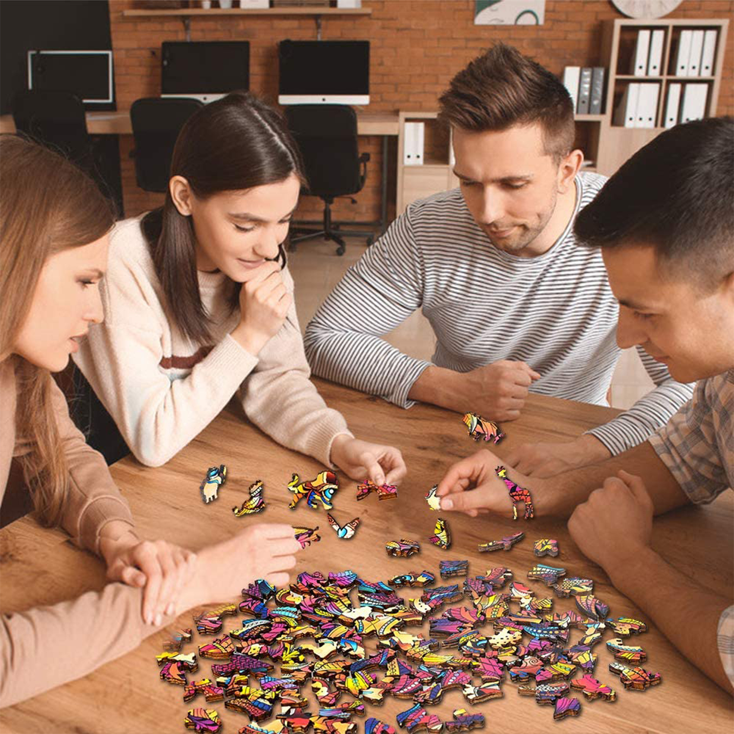 Quattro persone compongono un colorito puzzle di animali in legno su un tavolo.
