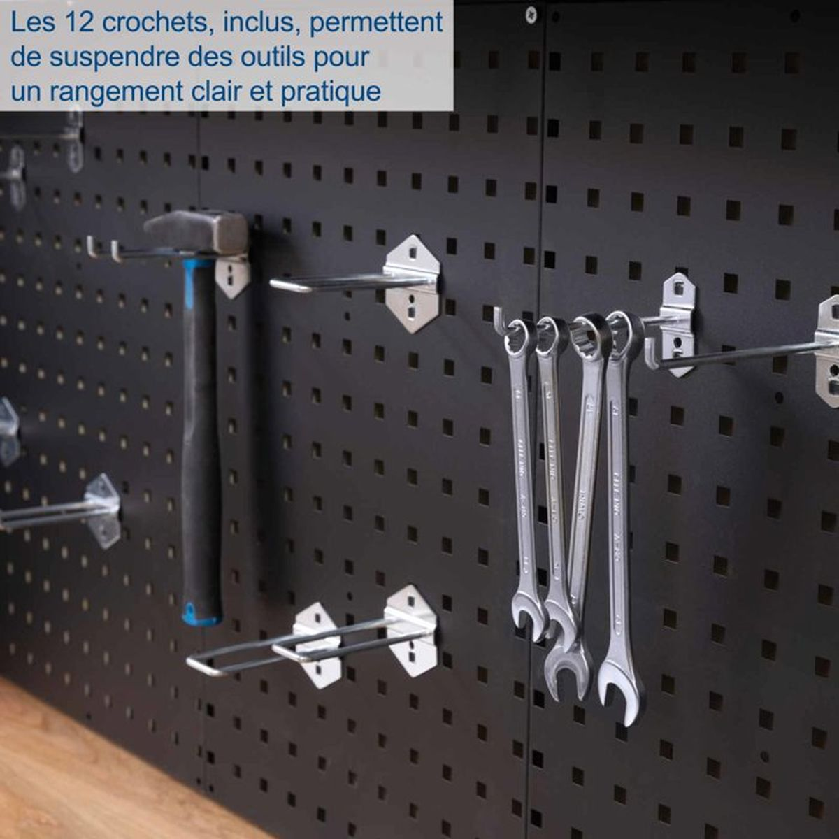 Ein Hammer und Schraubenschlüssel hängen an einer schwarzen Werkzeugwand mit Haken.