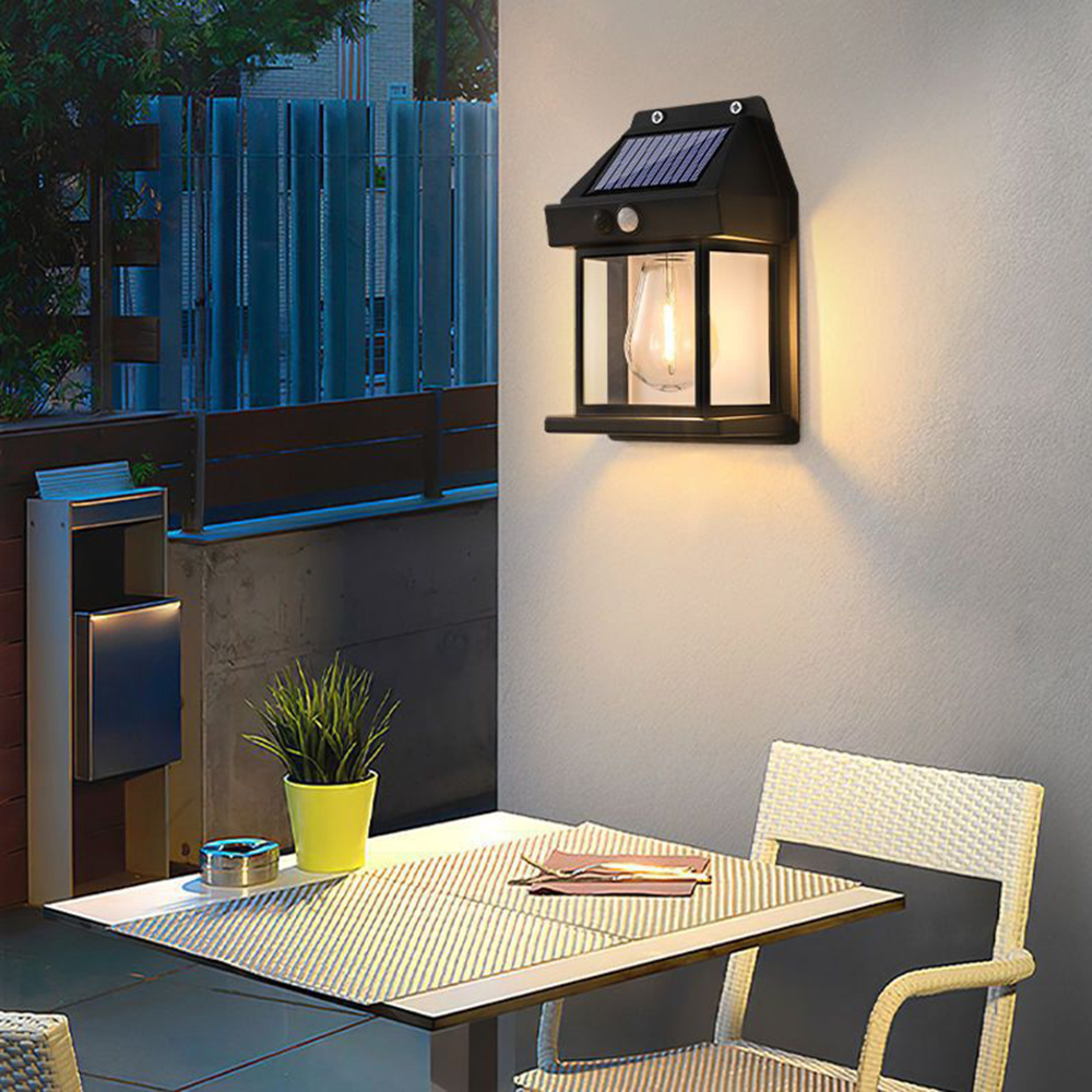 Solarleuchte an Wand montiert, beleuchtet Tisch mit Stuhl davor.