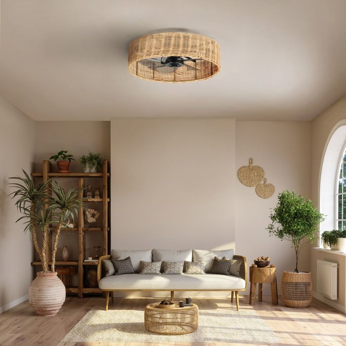 Een woonkamer met bank, salontafel, planten en een plafondventilator van rotan.