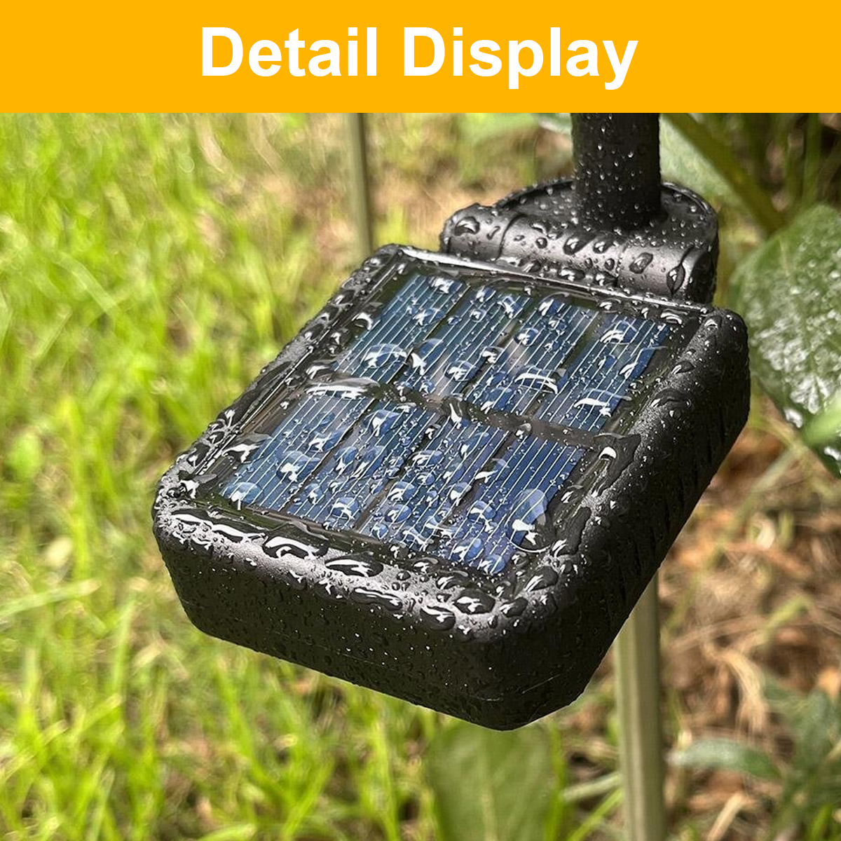 Ein schwarzes Solarpanel mit Wassertropfen im Gras.