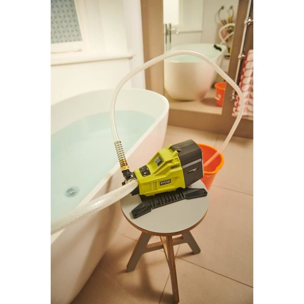 Eine gelbe Pumpe steht auf einem Hocker neben einer Badewanne mit Wasser.
