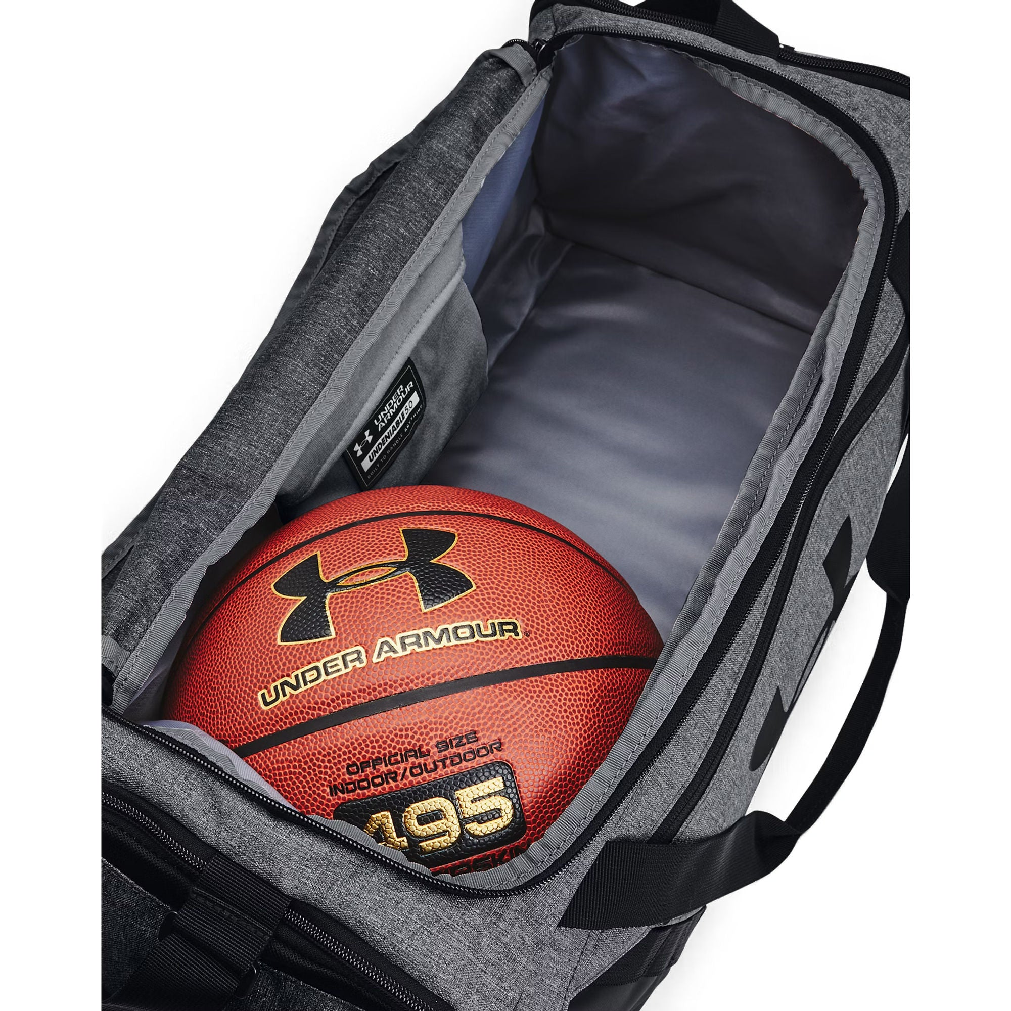 Ein Basketball liegt in einer grauen Sporttasche mit der Aufschrift Under Armour.