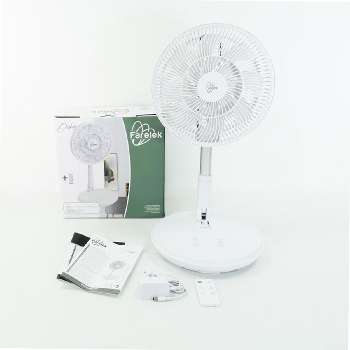 Een witte staande ventilator met doos, handleiding, oplader en afstandsbediening.