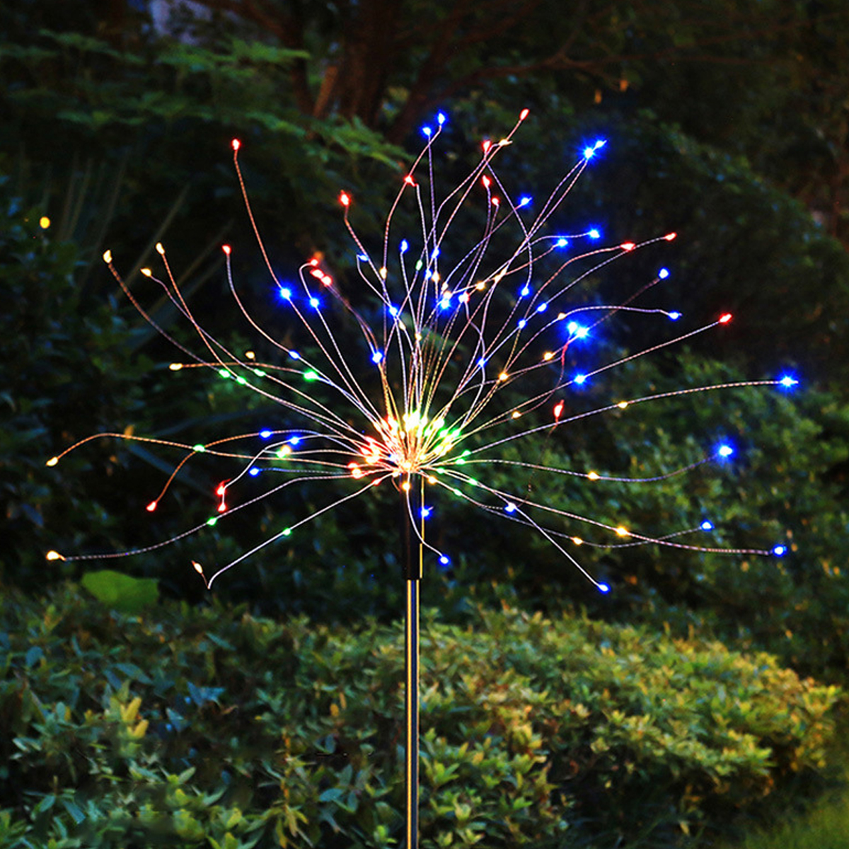 Eine Sternenlicht-Gartenleuchte mit bunten LEDs an dünnen Drähten vor dunklem Laub.