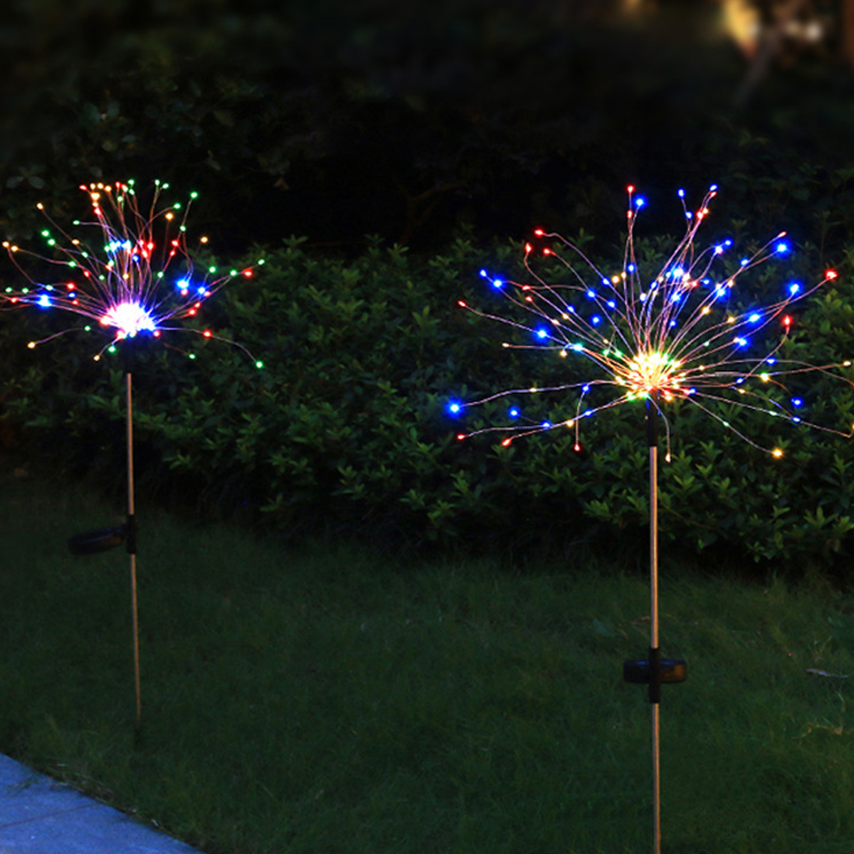 Zwei leuchtende Gartenleuchten mit bunten LEDs, die wie Feuerwerk aussehen.