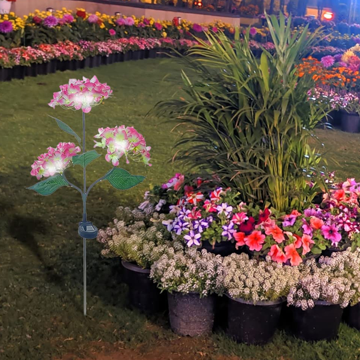 Solarbetriebene Lampe in Form von rosa Hortensien mit grünen Blättern auf einem Stab.