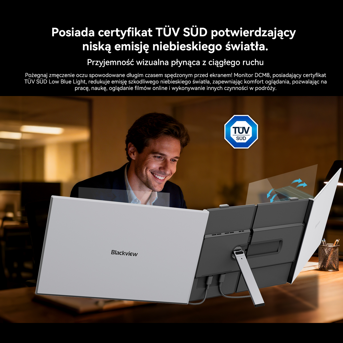 Mężczyzna uśmiecha się do laptopa z pieczęcią TÜV. Ekrany są nachylone.