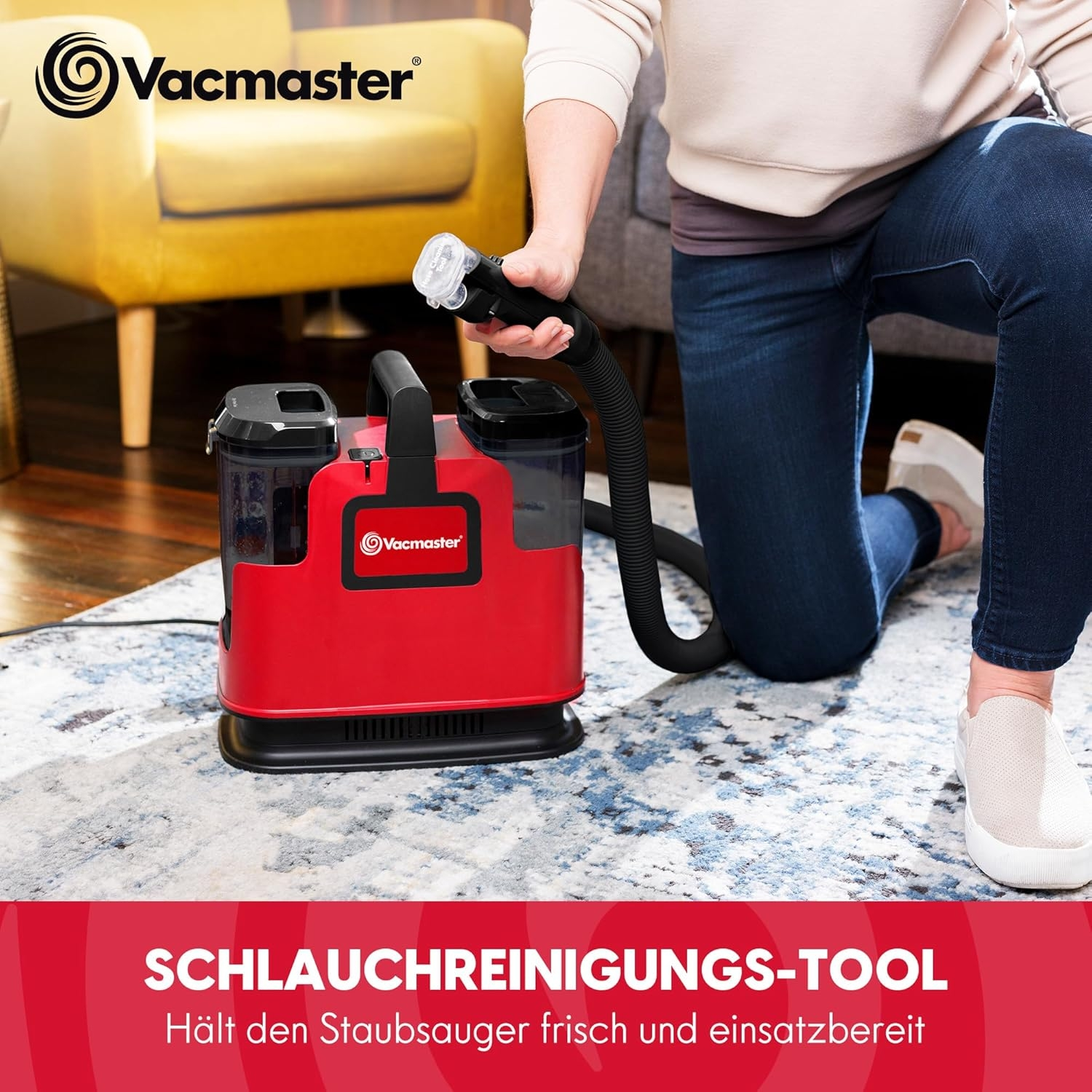 Ein roter Reiniger mit Schlauch und Aufsatz auf einem Teppich.