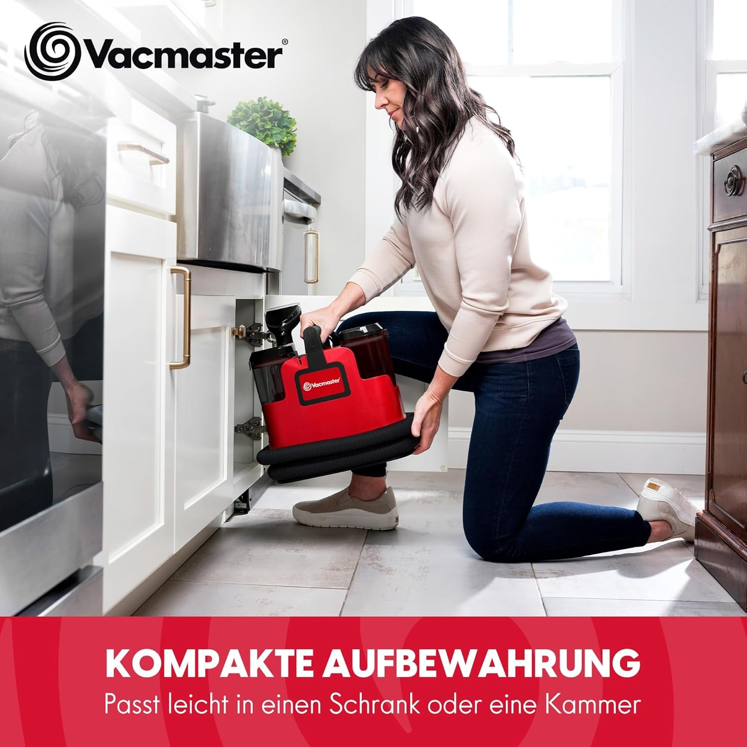 Frau verstaut roten Vacmaster Sauger im Küchenschrank.