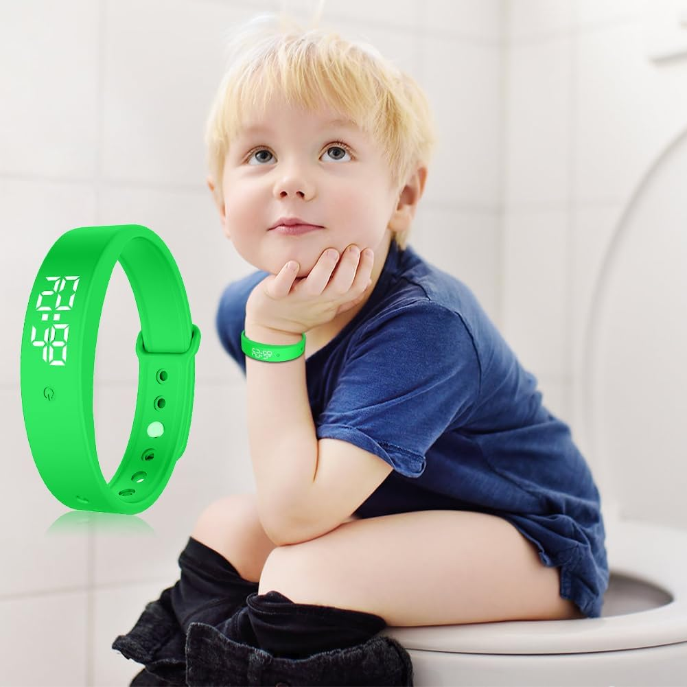 Ein Junge sitzt auf einer Toilette und trägt ein grünes Armband mit Digitalanzeige.