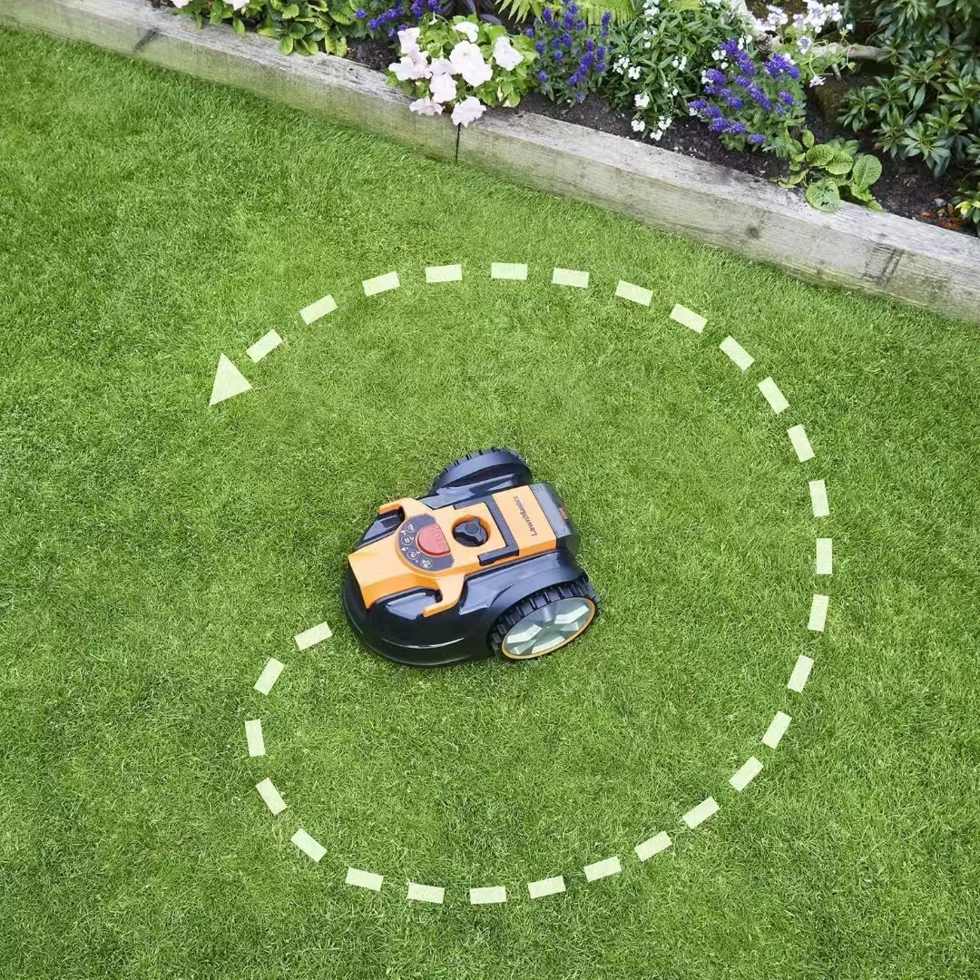 Ein Mähroboter fährt auf einem grünen Rasen, umgeben von einer gestrichelten Linie.