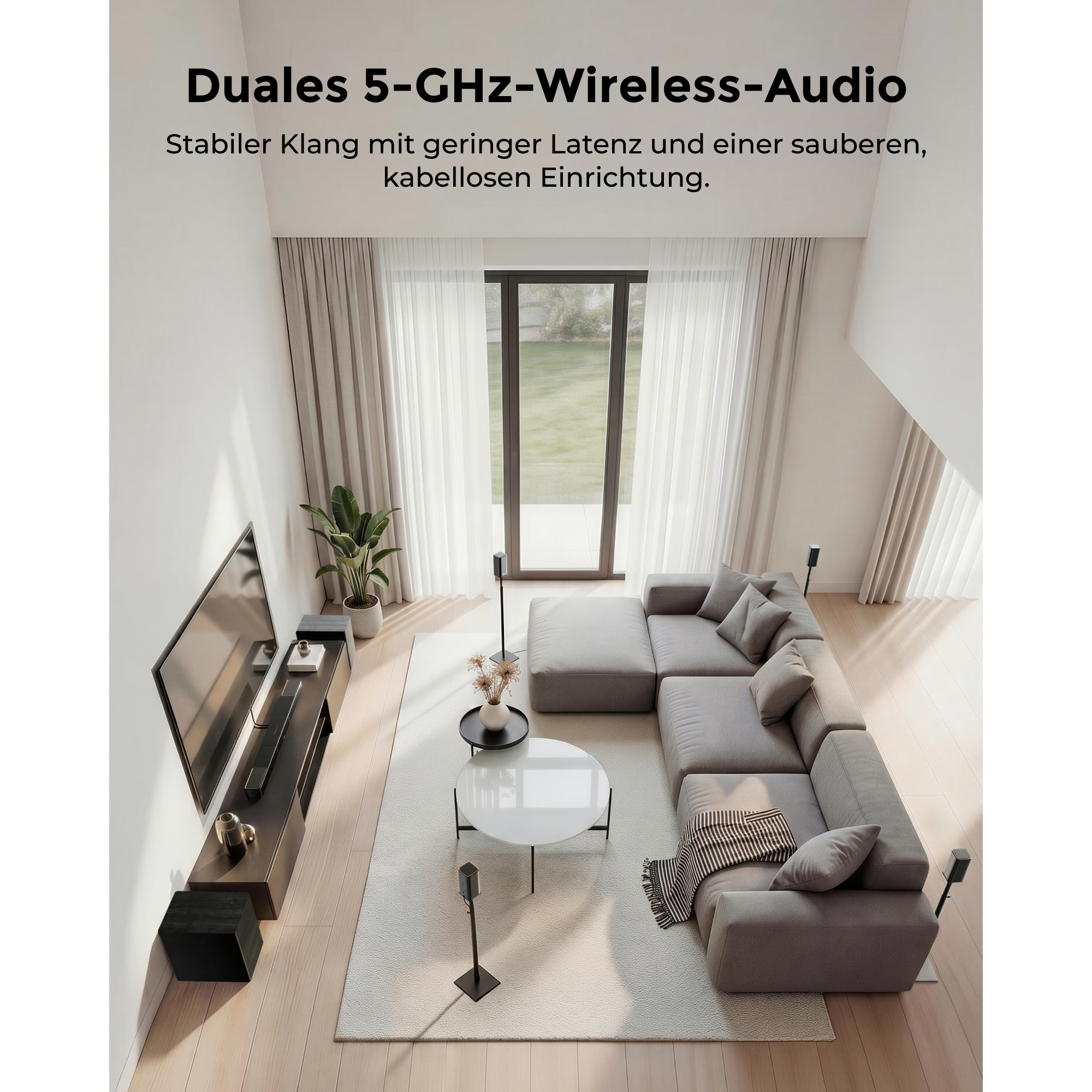 Modernes Wohnzimmer mit grauem Ecksofa, TV und Lautsprechern.