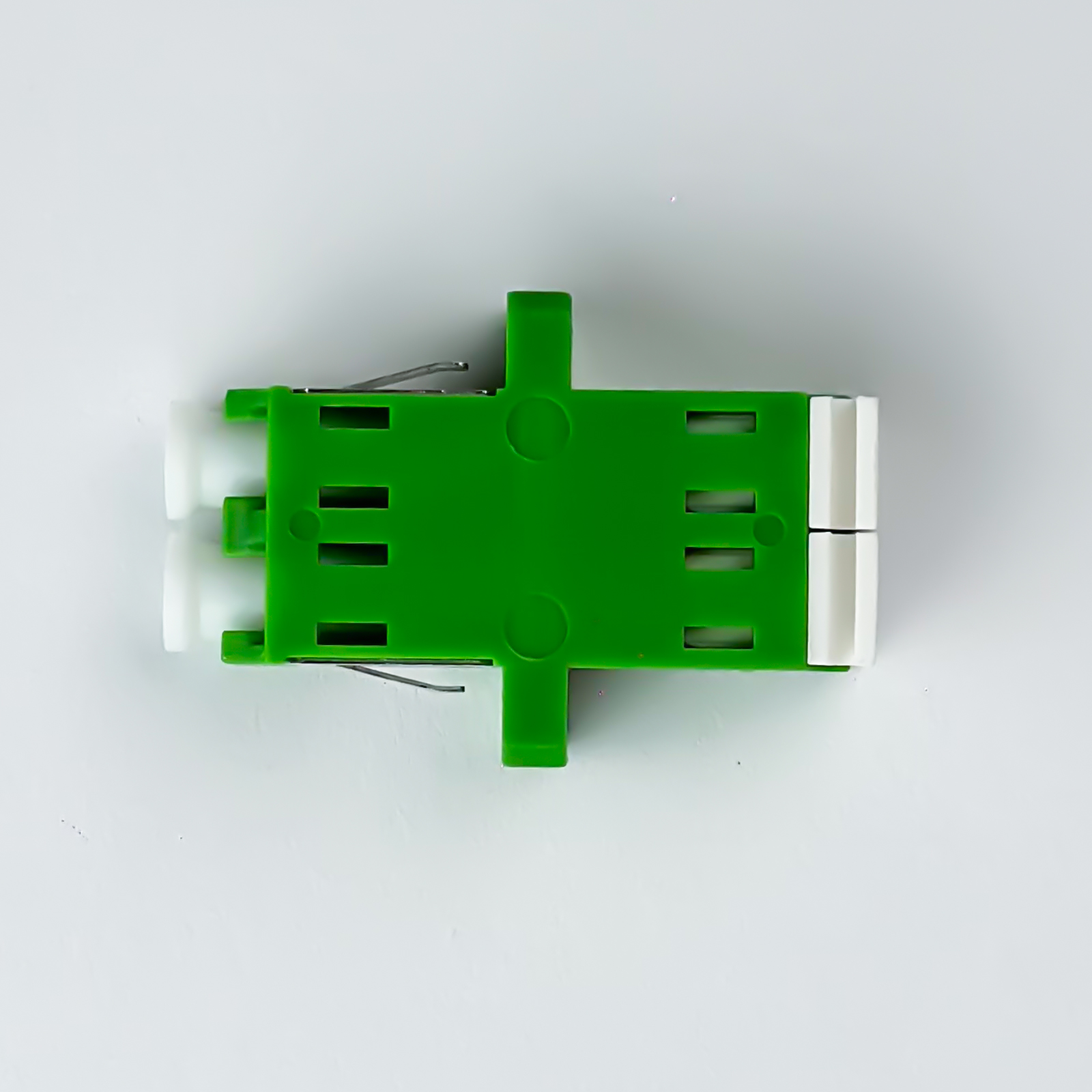 Ein grüner Stecker mit weißen Enden auf weißem Hintergrund.