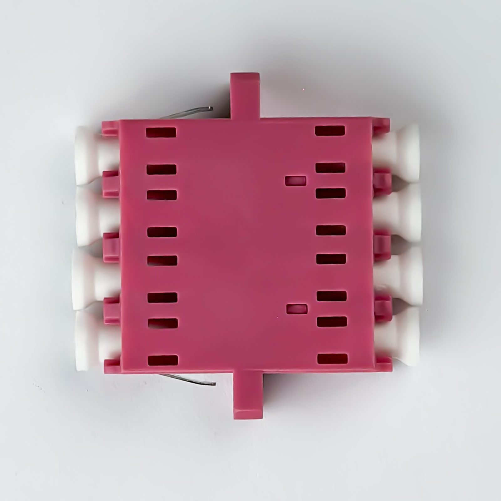 Ein pinker Kunststoffgegenstand mit weißen Rollen und Schlitzen.