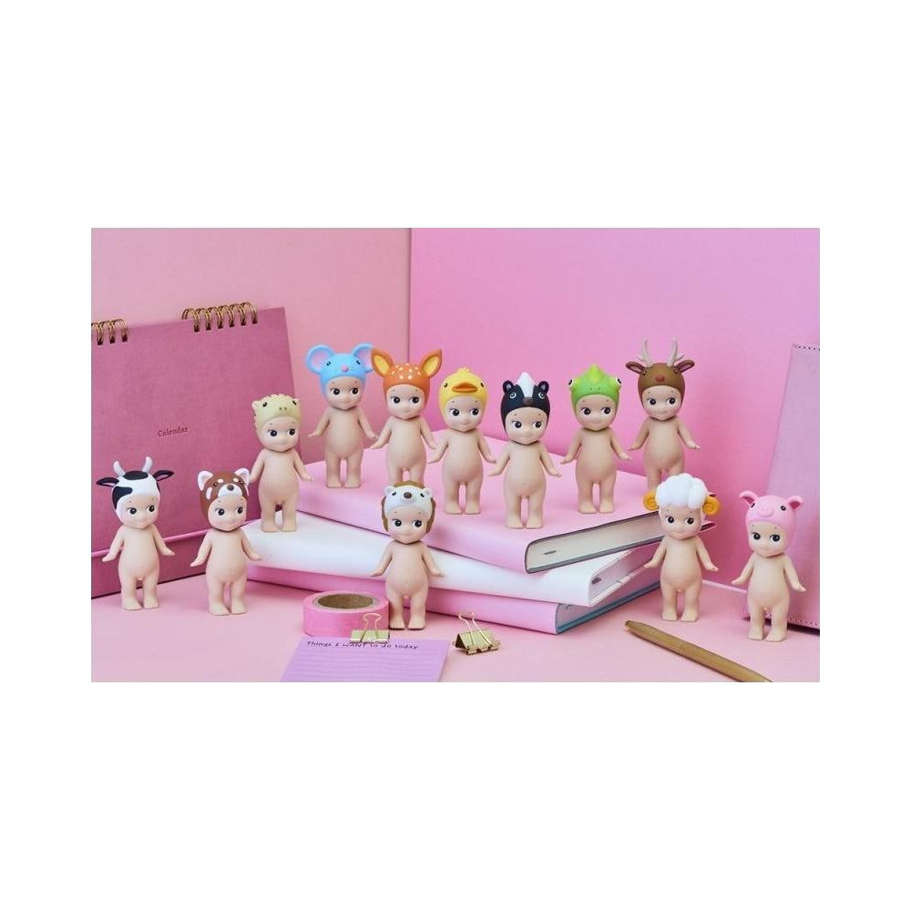 Zwölf kleine Figuren mit Tierkopfbedeckungen stehen vor Büchern und einem Kalender.