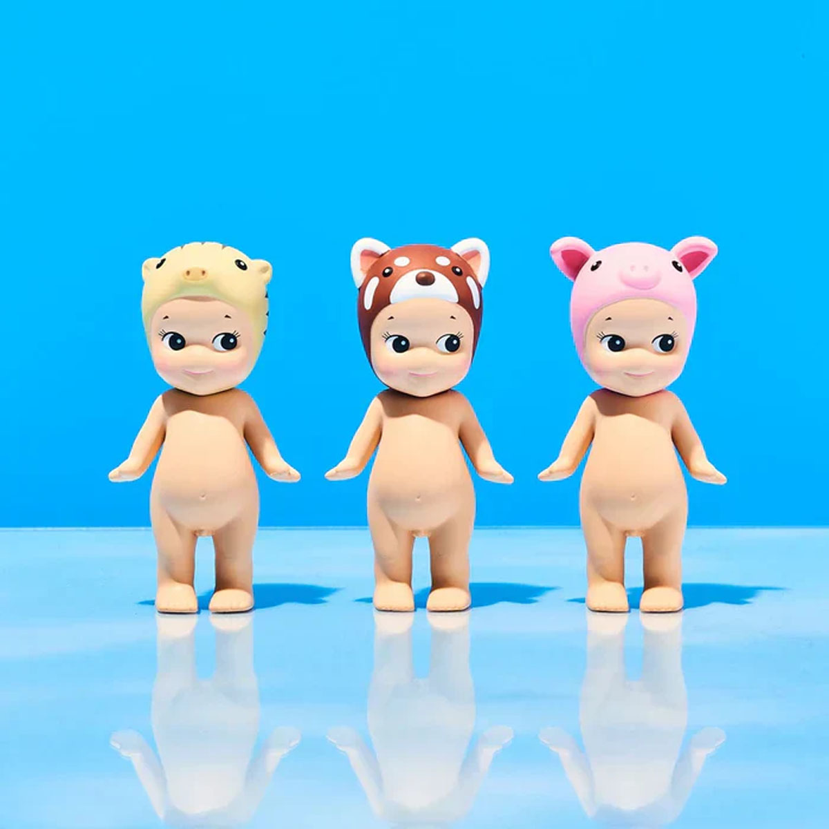 Drei Sonny Angels in Tierkostümen: gelber Tiger, brauner Panda und rosa Schwein.