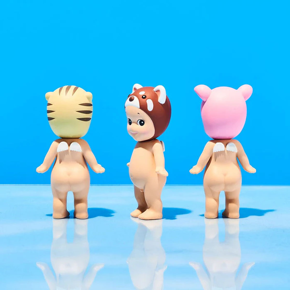 Drei Figuren mit Flügeln: eine mit Tigerkopf, eine mit Rotpandabearbeitung und eine mit Schweinekopf.