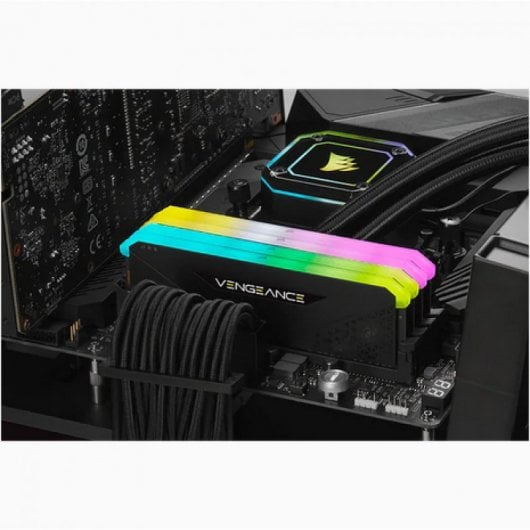 Un módulo RAM negro con iluminación RGB en azul, amarillo y rosa sobre una placa base.