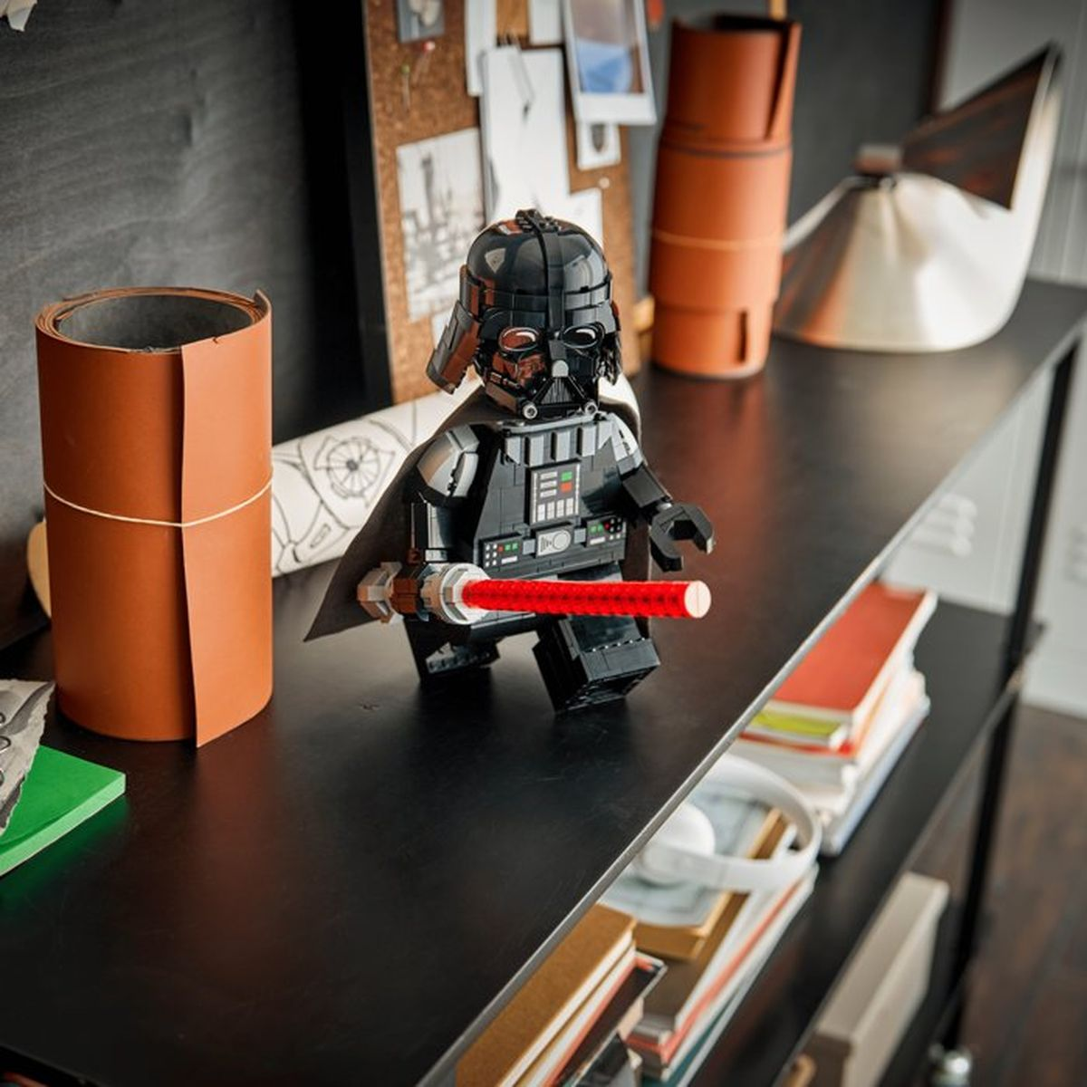 Kırmızı ışın kılıcı tutan Lego Darth Vader figürü rafta duruyor.