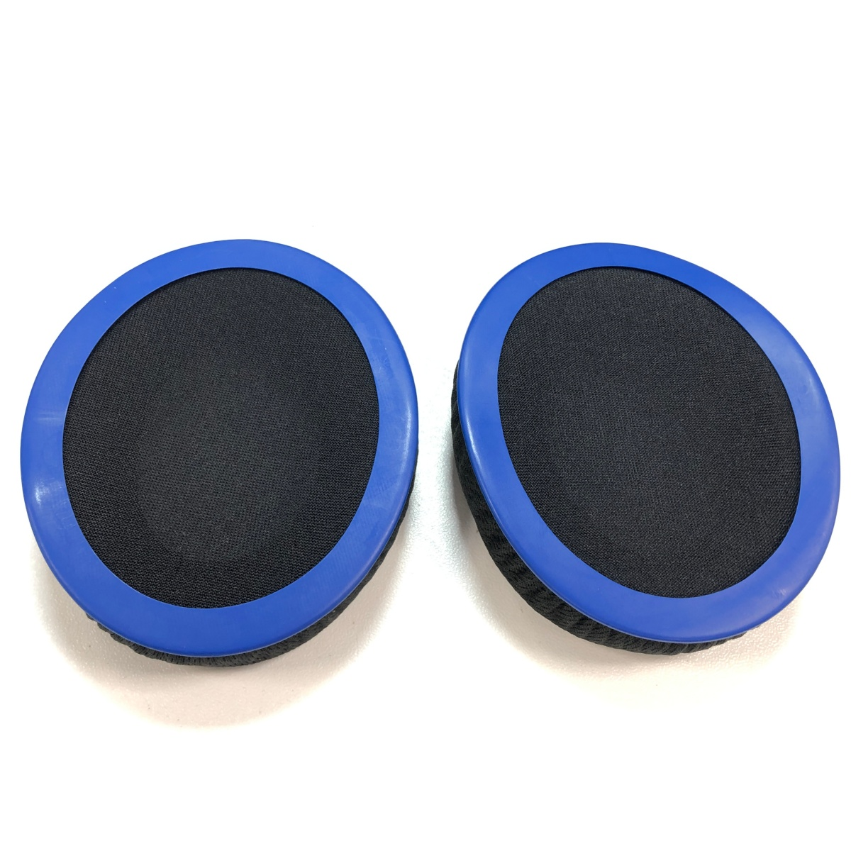 Due cuscinetti auricolari neri rotondi con bordo blu sono uno accanto all'altro.