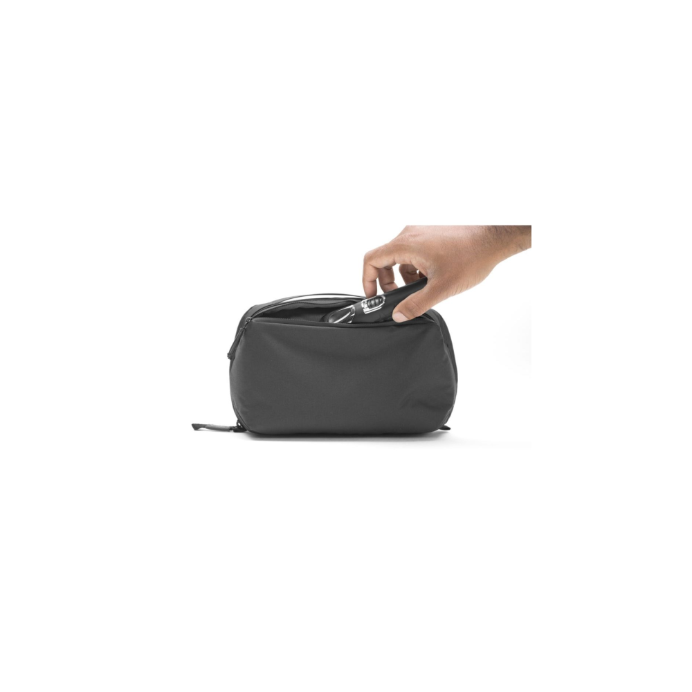A hand places keys into a black pouch.
