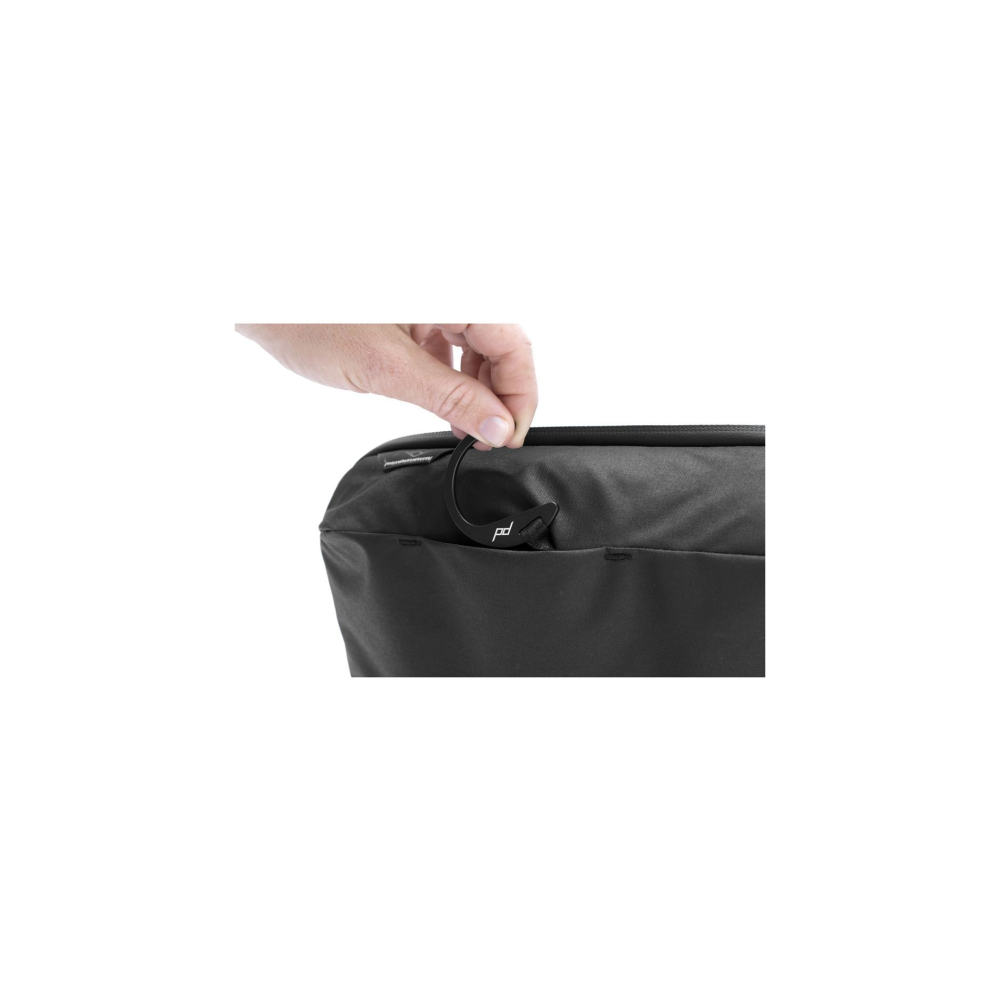 A hand holds a black hook with PD logo on a black bag.